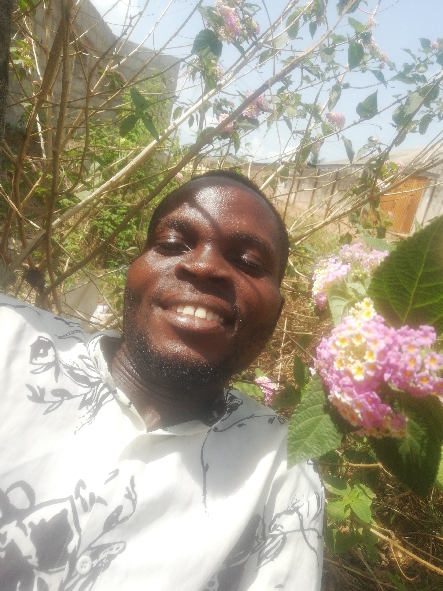 Man photographed with flowers near concrete wall in urban setting