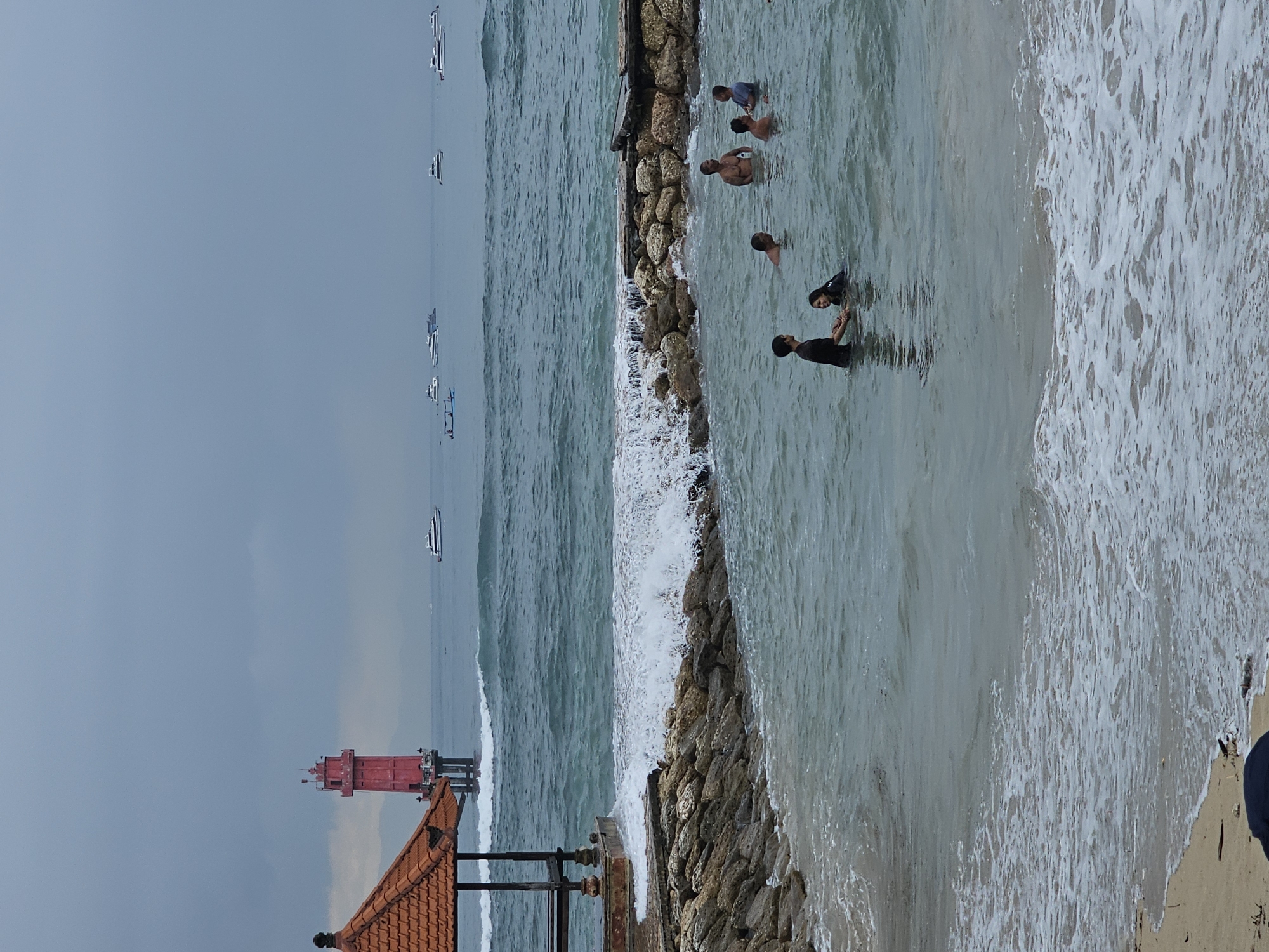 Temple visitors and boats observed at Denpasar coastline