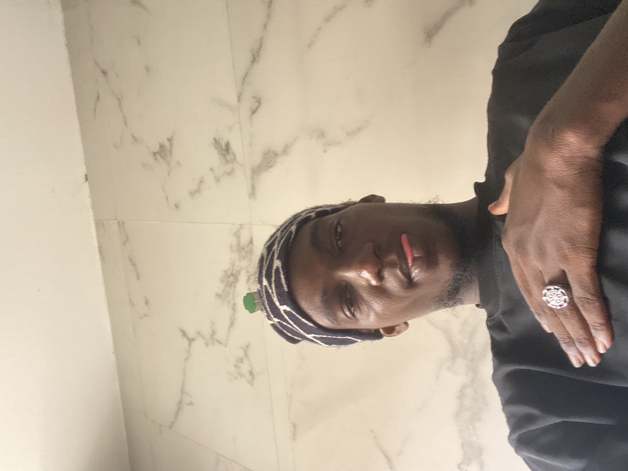 Man in patterned head covering photographed at unknown location