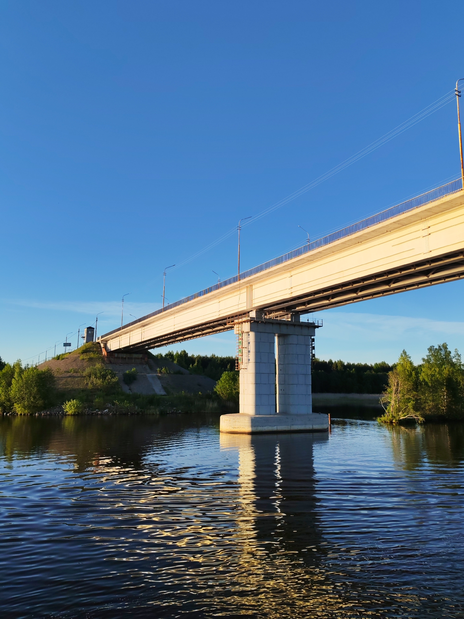 Vessel transits Sheksna River under concrete bridge, Russia