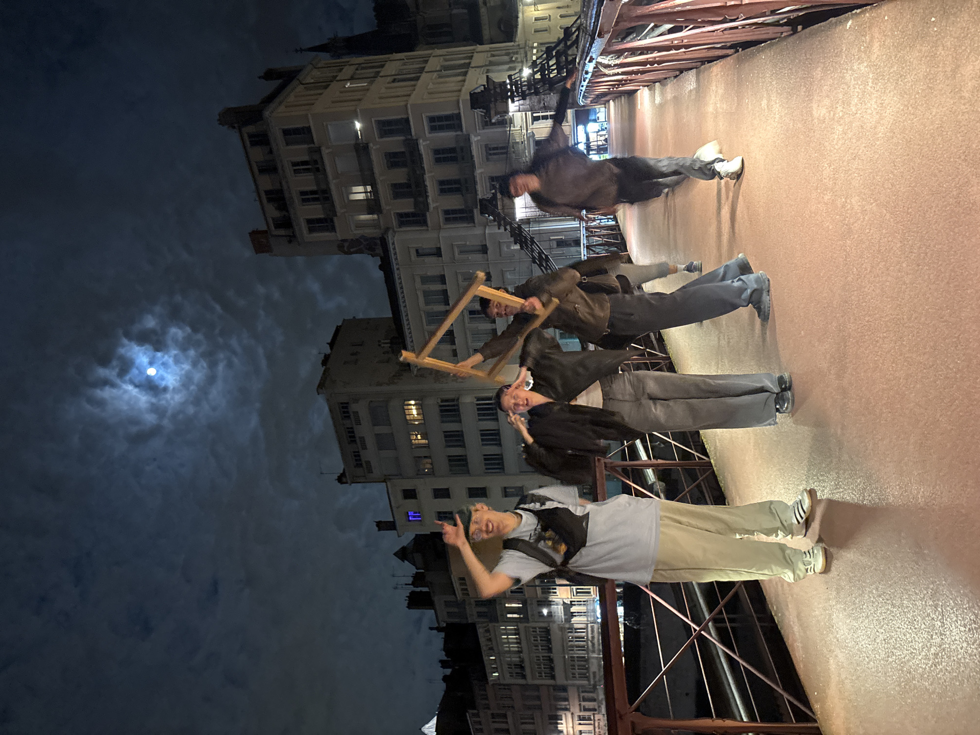 Young men pose for nighttime photos on Lyon bridge