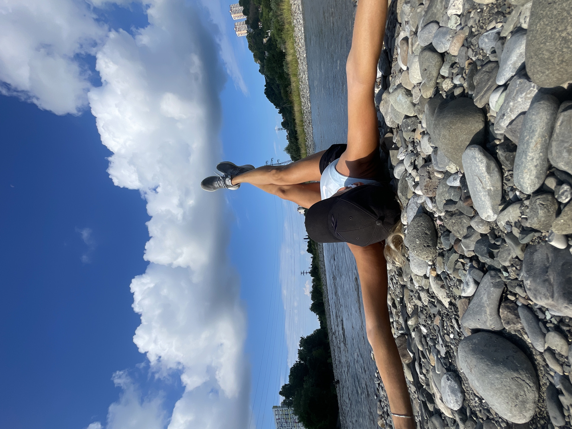 Relaxing on a rocky shore, legs up toward the sky