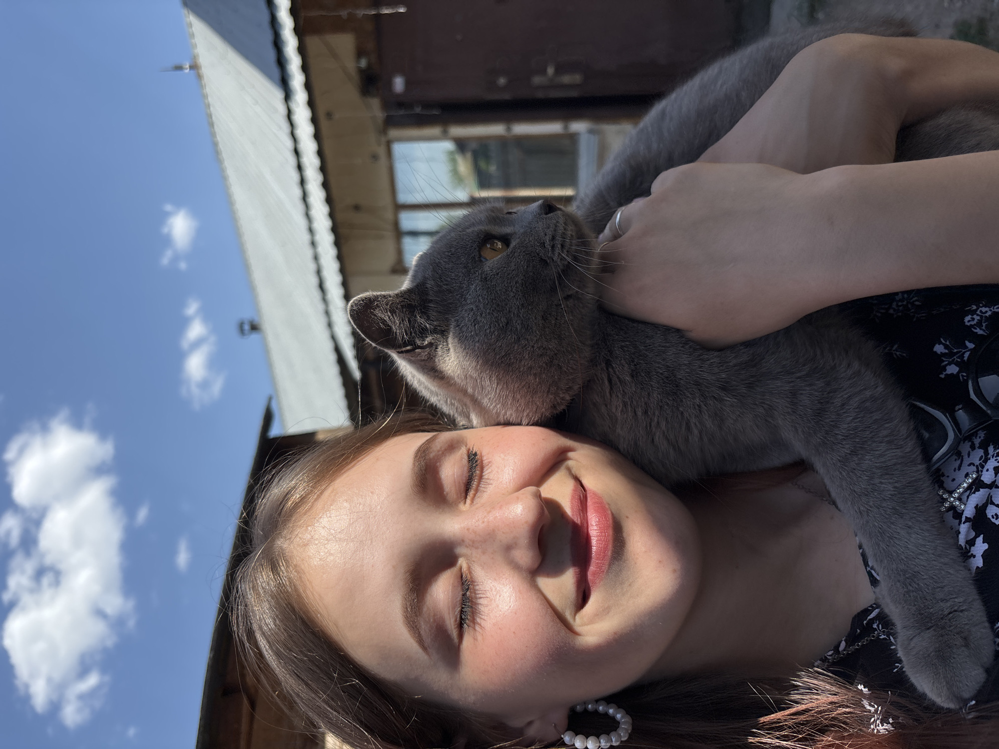 Woman enjoys peaceful moment with gray cat in Russia