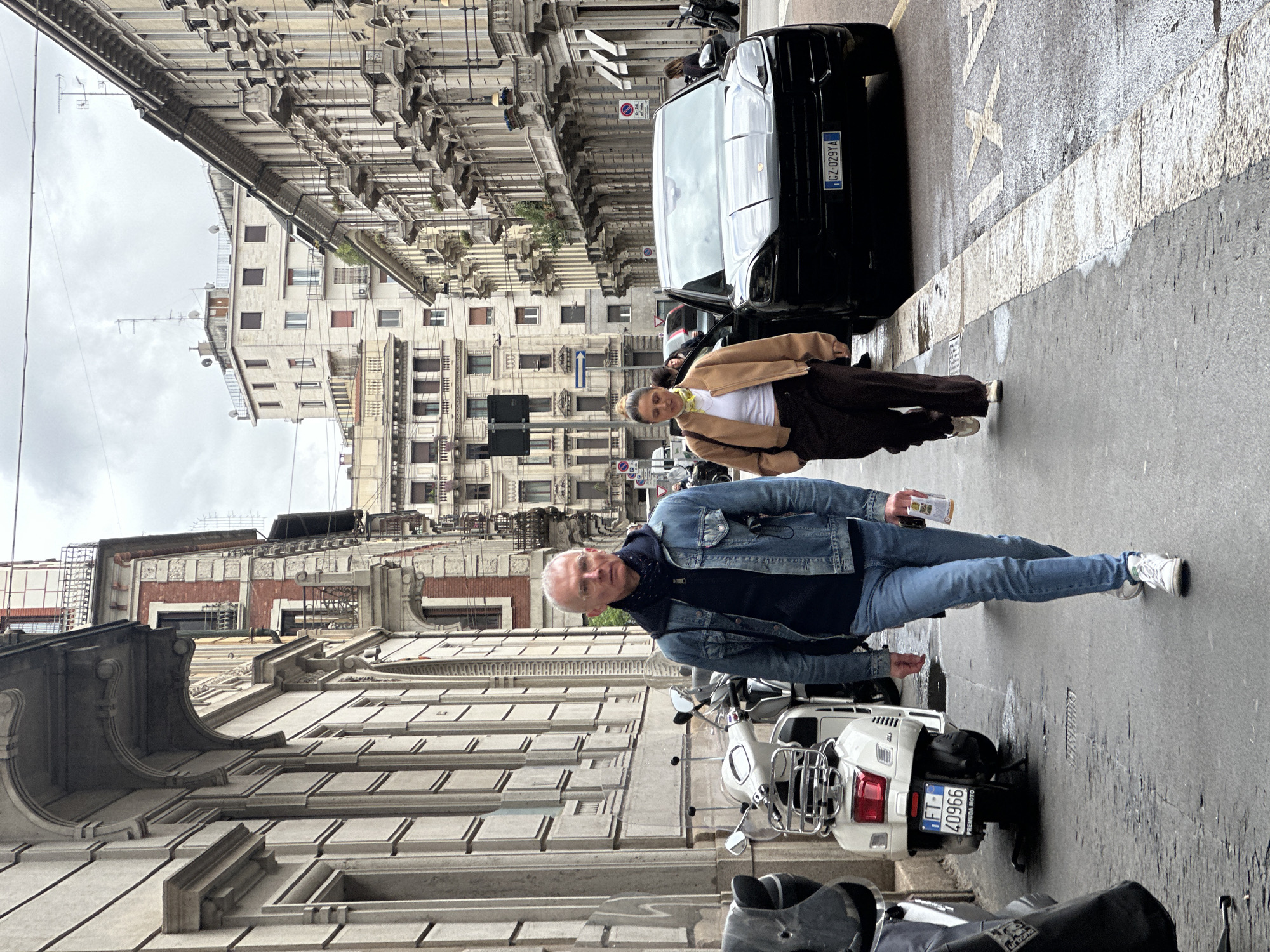 Two pedestrians walk Milan's narrow ornate streets