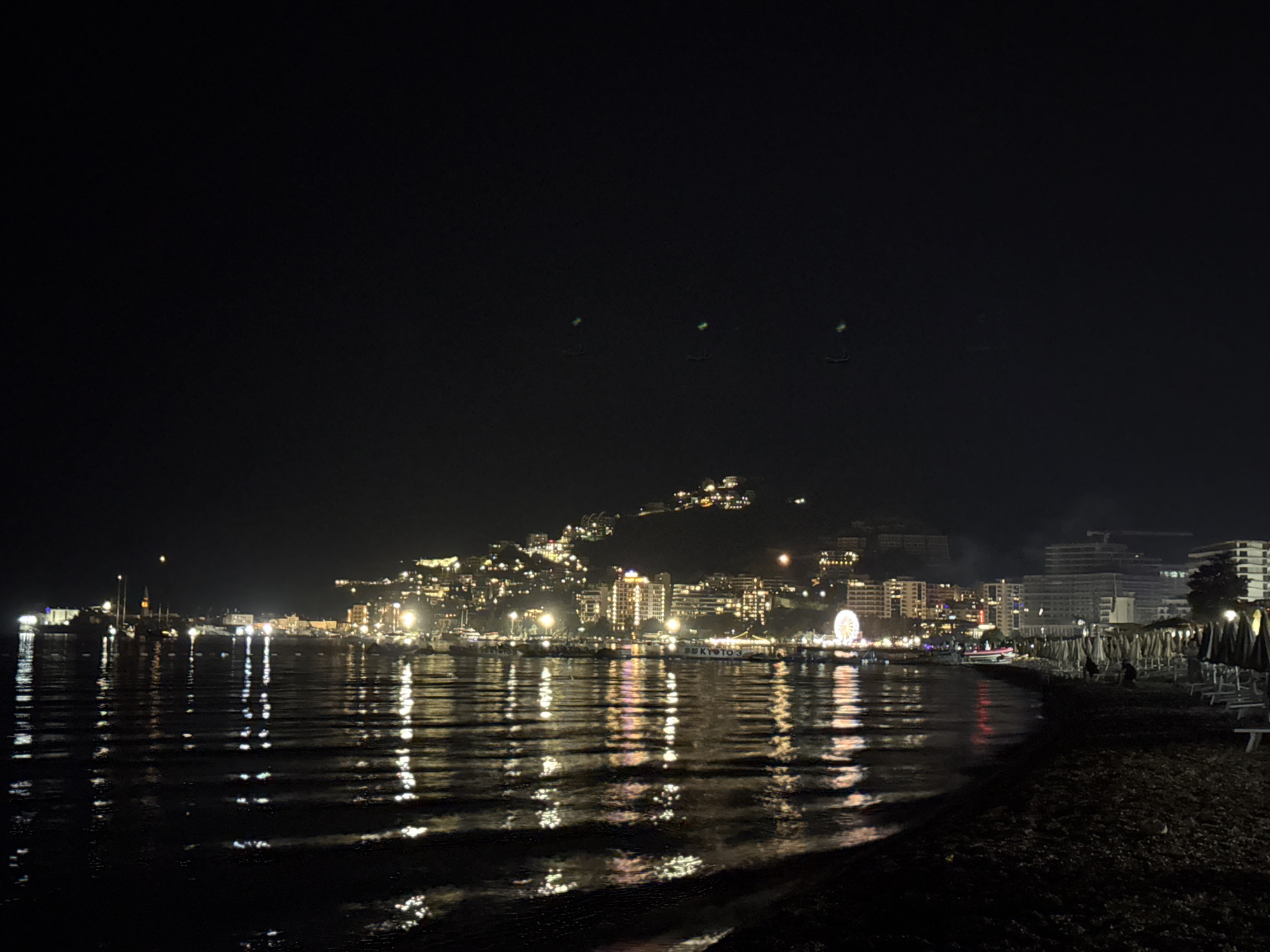 Budva riviera at night, Ferris wheel and coastline lights