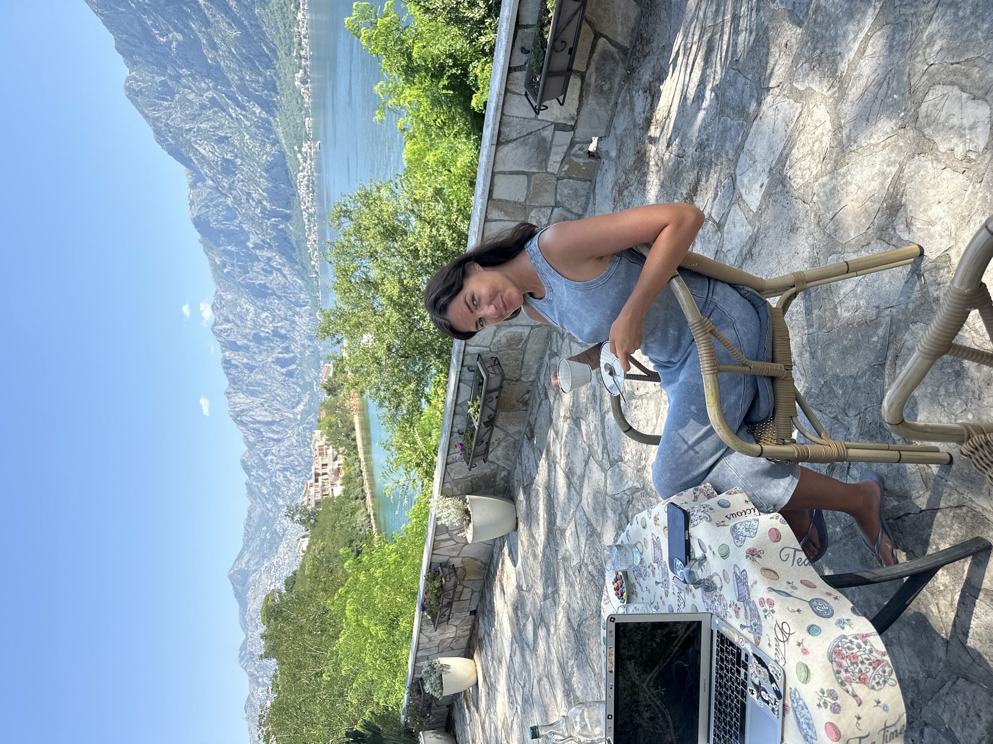 Laptop and coffee on a floral tablecloth in coastal Montenegro