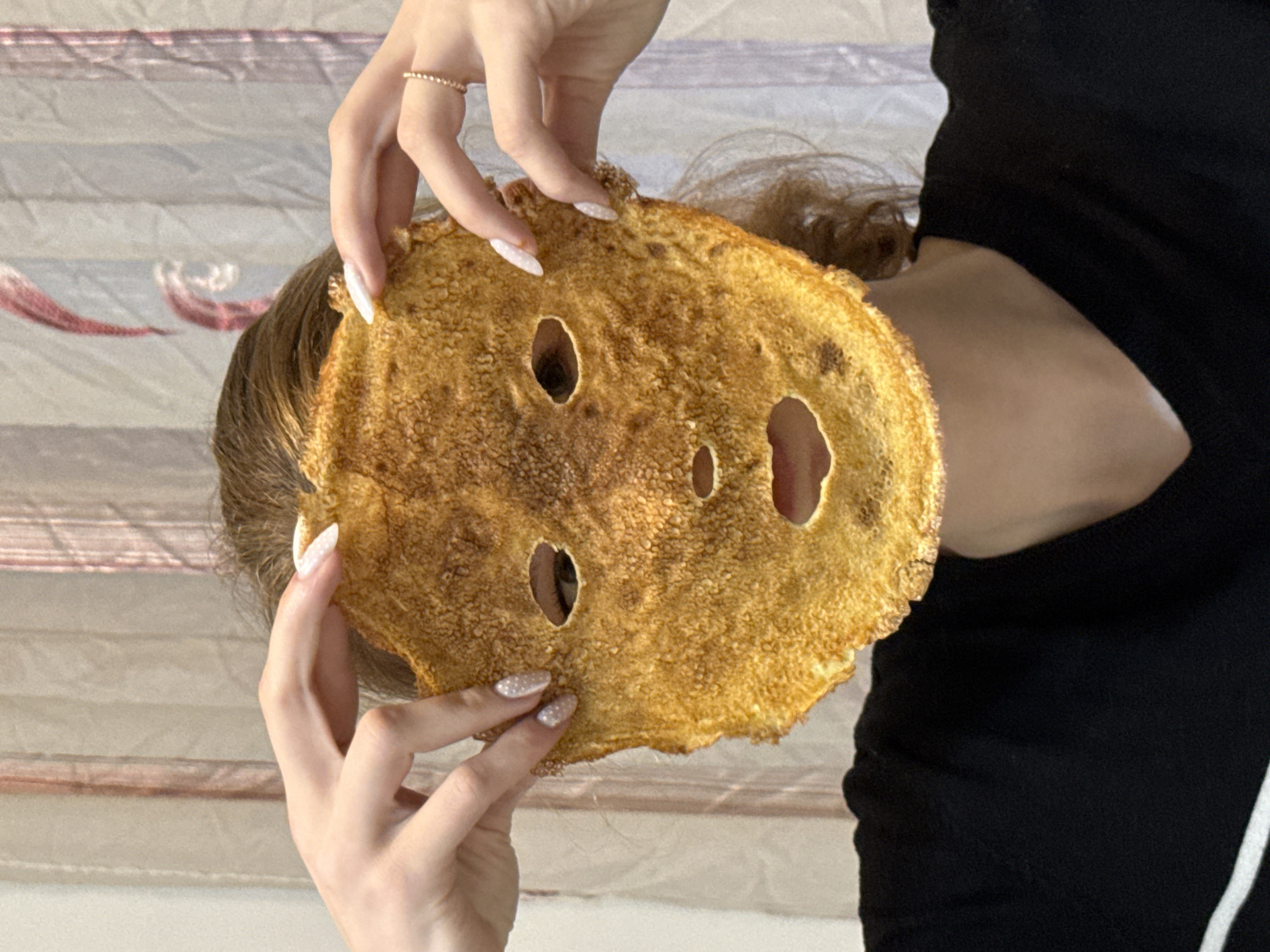 Woman uses holey pancake as playful face mask in Serbia