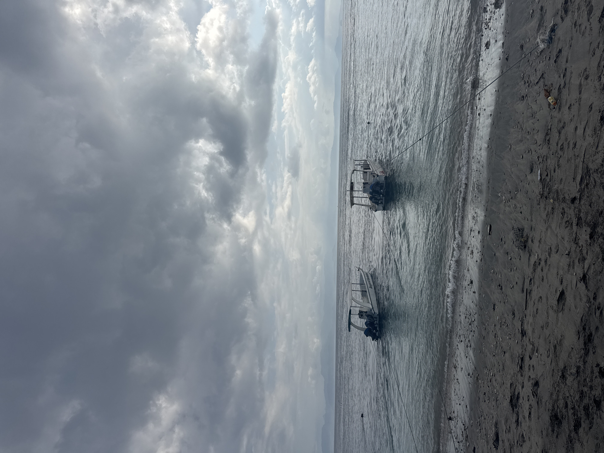 Dark sand, speedboats, and beach life on Nusa Penida