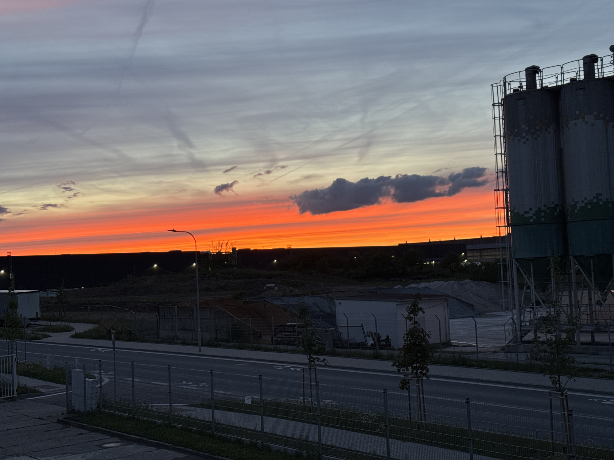 Dramatic sunset illuminates industrial landscape in Pilsen, Czechia