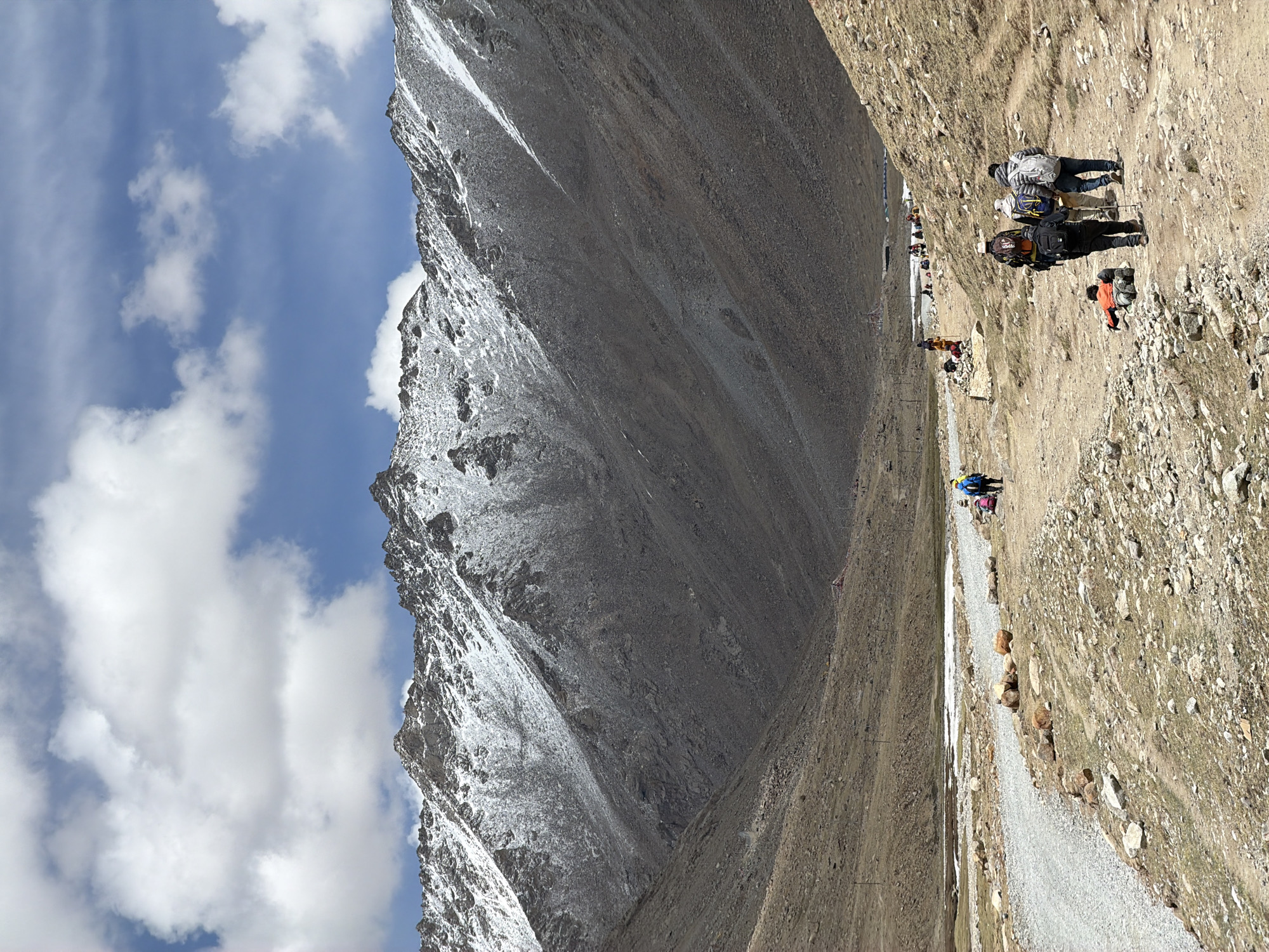 Mountain travelers with pack animals traverse rocky path in China