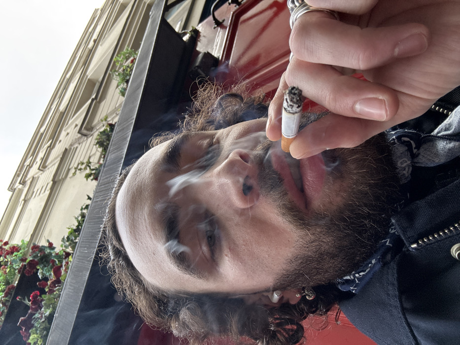 Man photographed smoking near red door in Paris