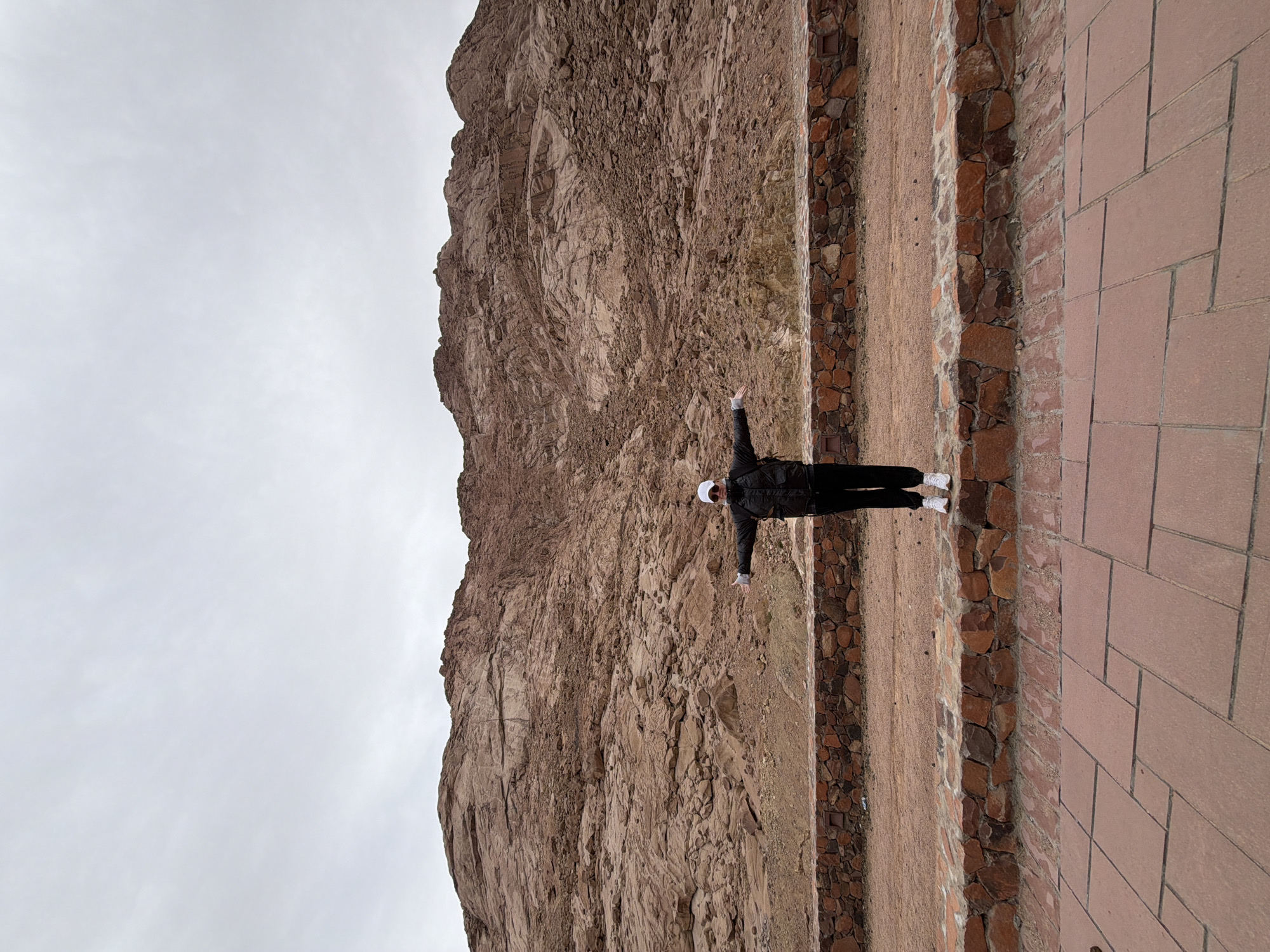 Tourist poses with outstretched arms in Saint Catherine mountains