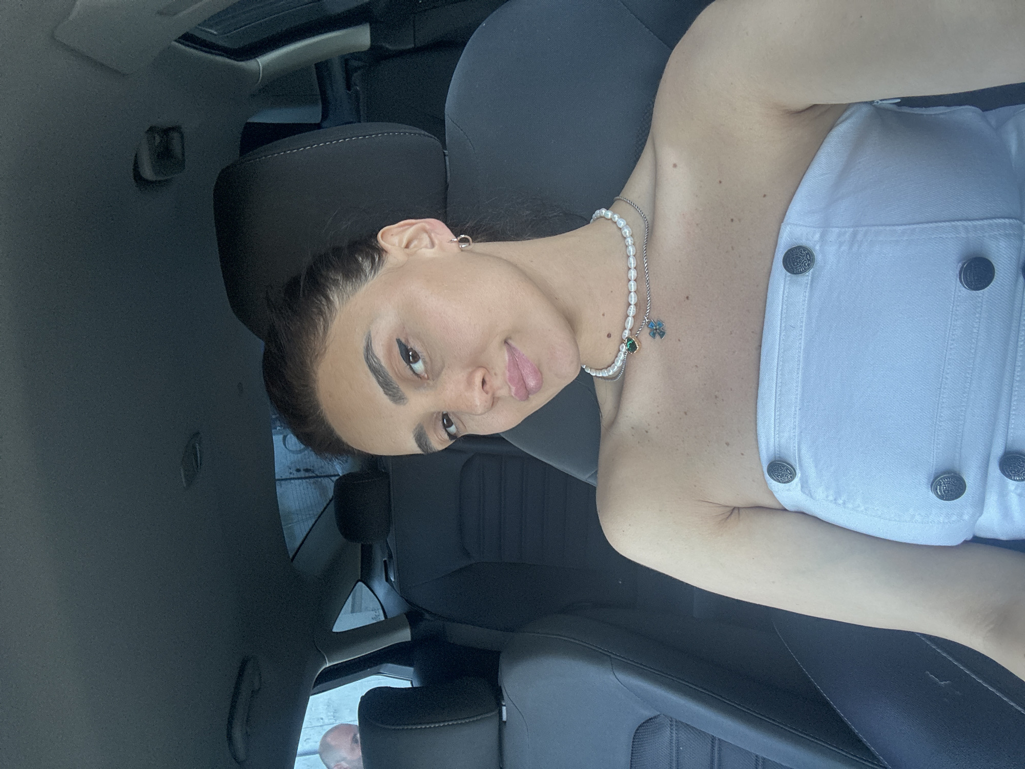 Driver in car wearing white top and pearls, Tbilisi