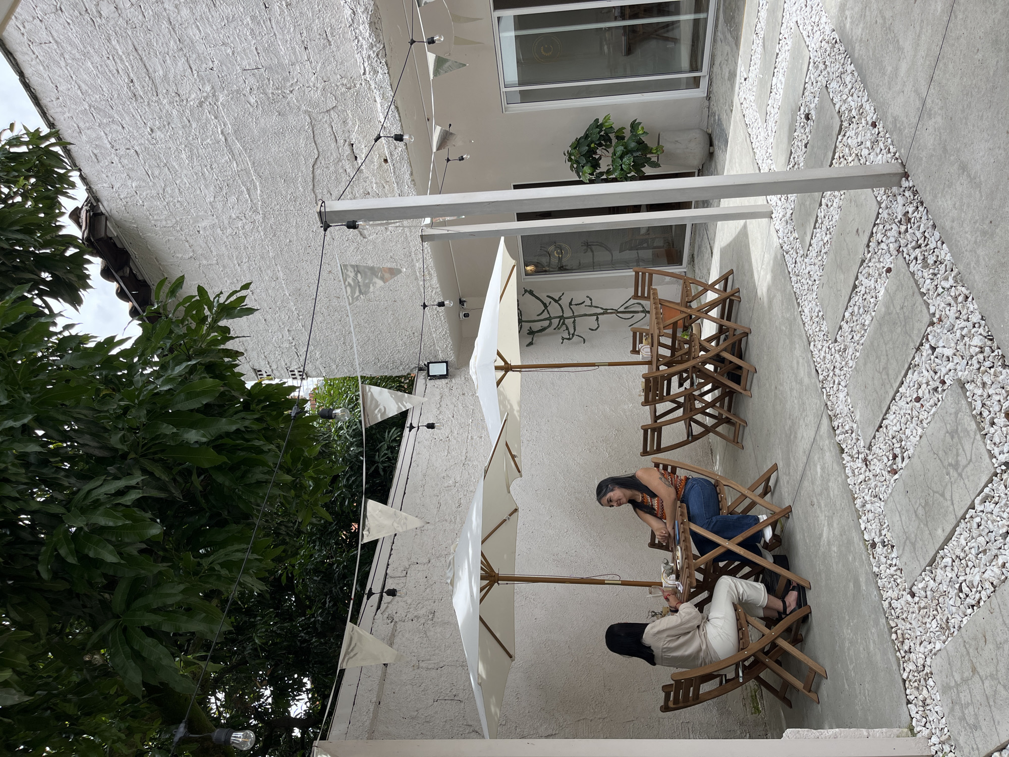 Women gather at outdoor patio table in Medellín