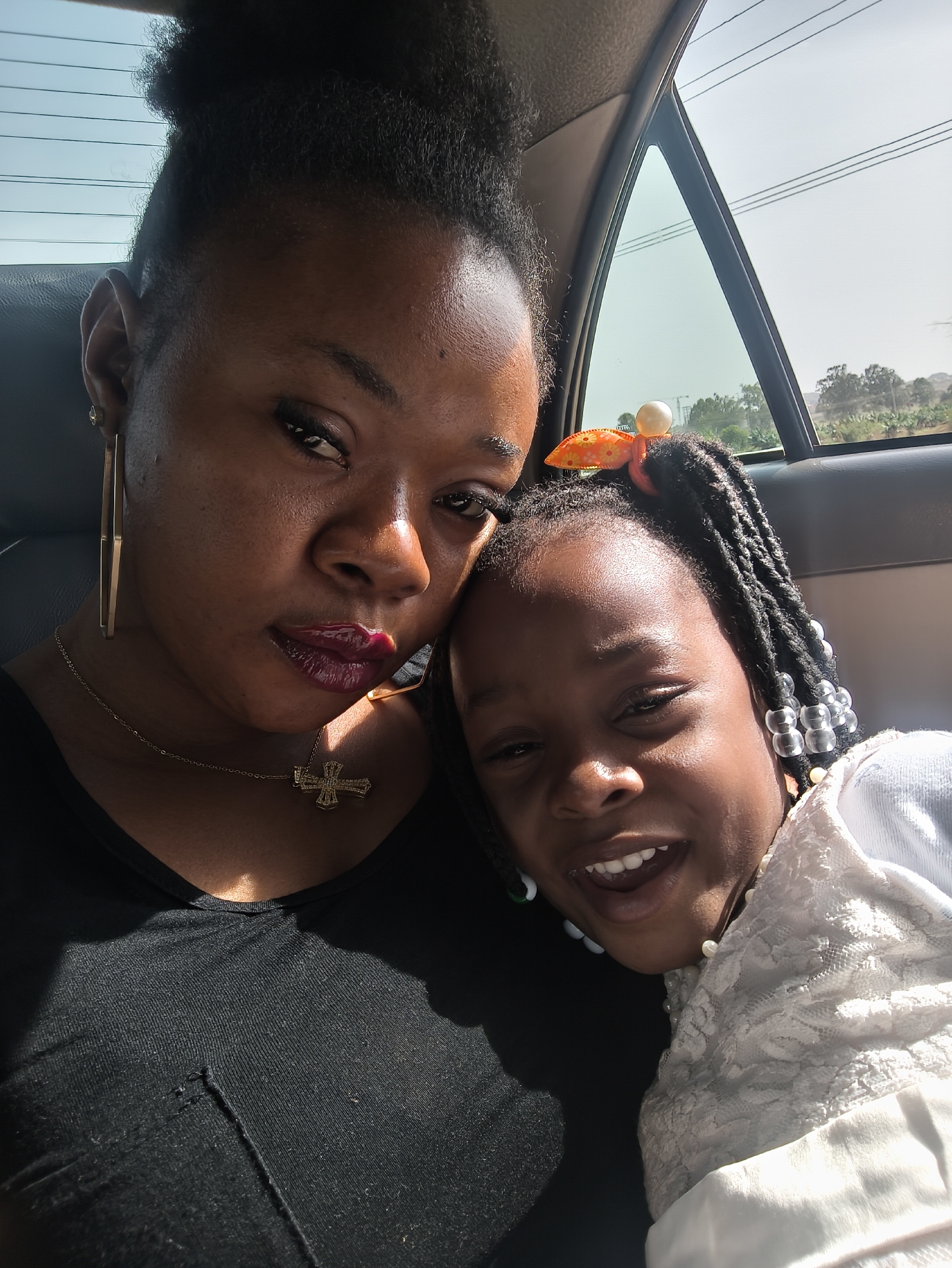 Mother and daughter photographed together in car in Jos