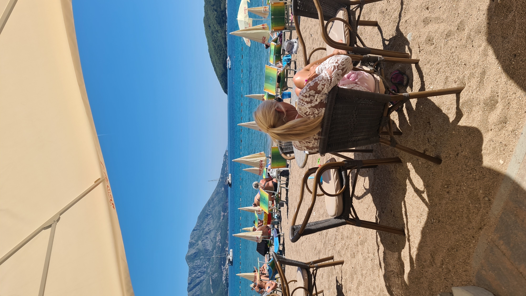 Woman enjoys beachside cafe moment in Budva, Montenegro