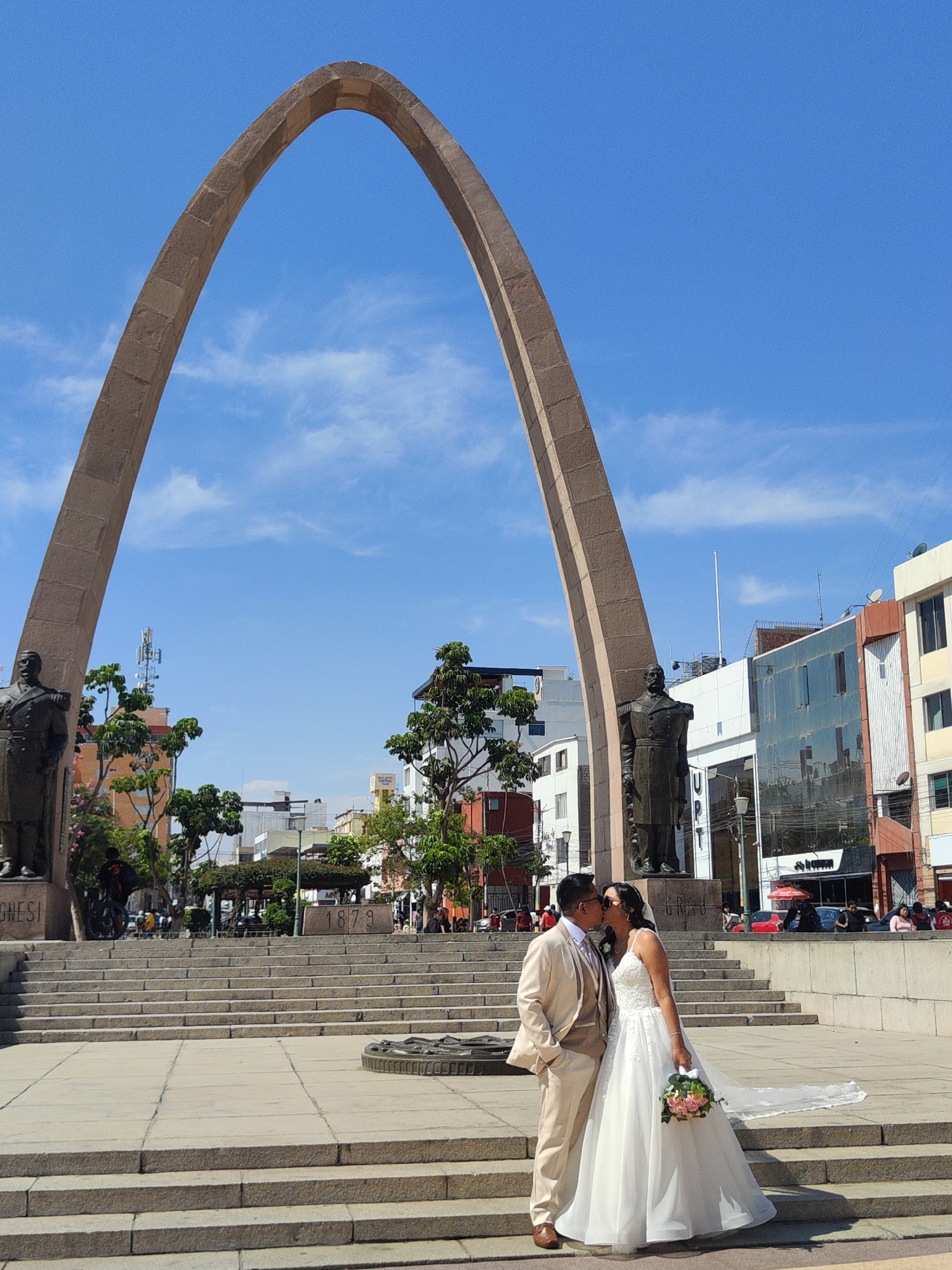 Wedding couple photographs at historic Tacna landmarks, local market active