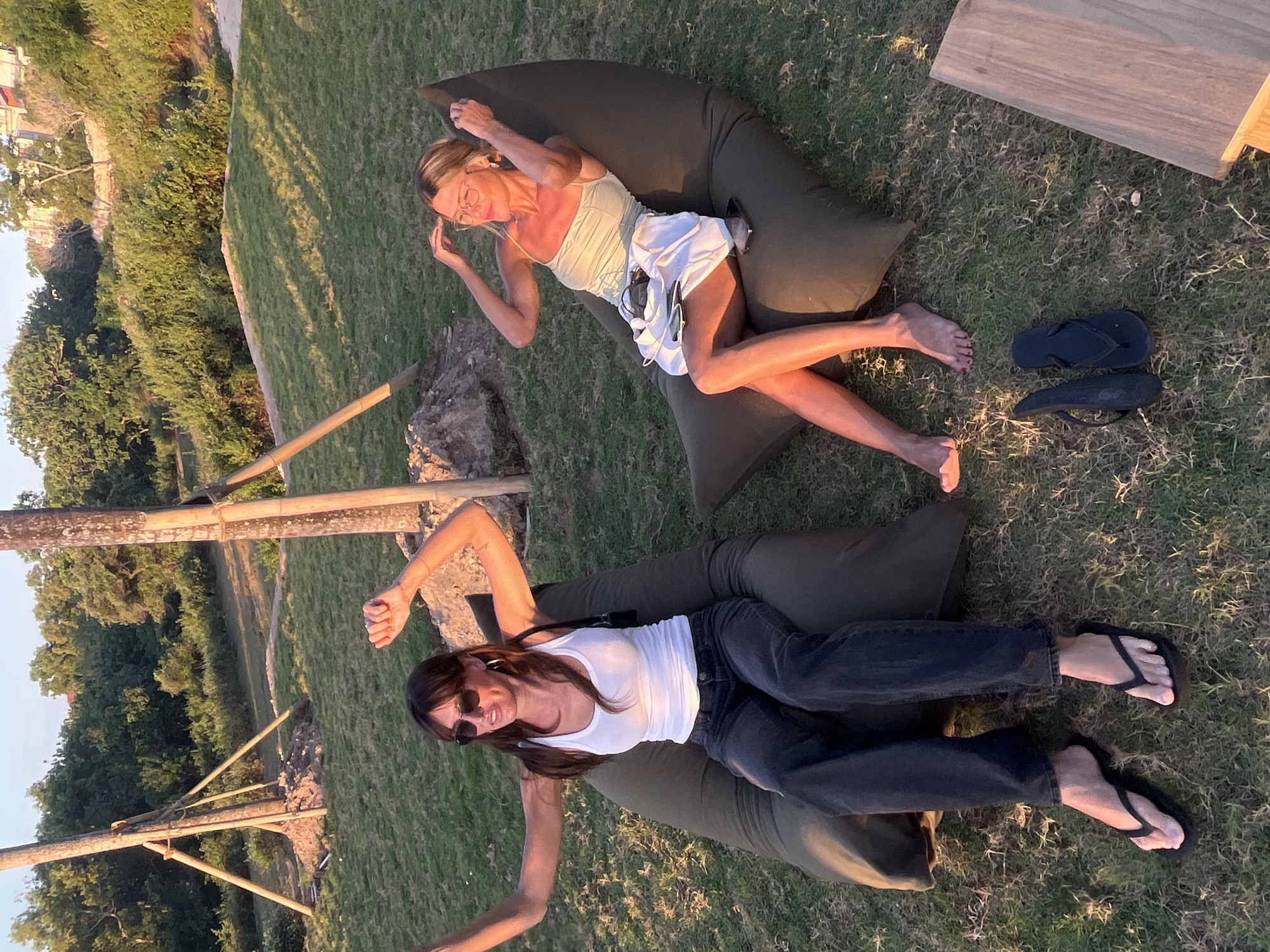 Sunset hangout on a grassy Bali hillside overlooking the ocean
