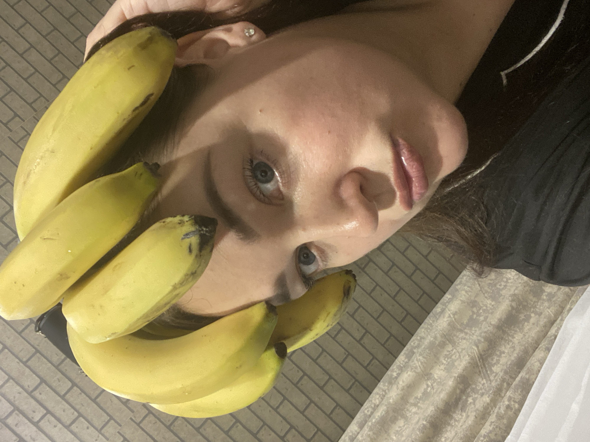 Woman poses with bananas in playful indoor photo session