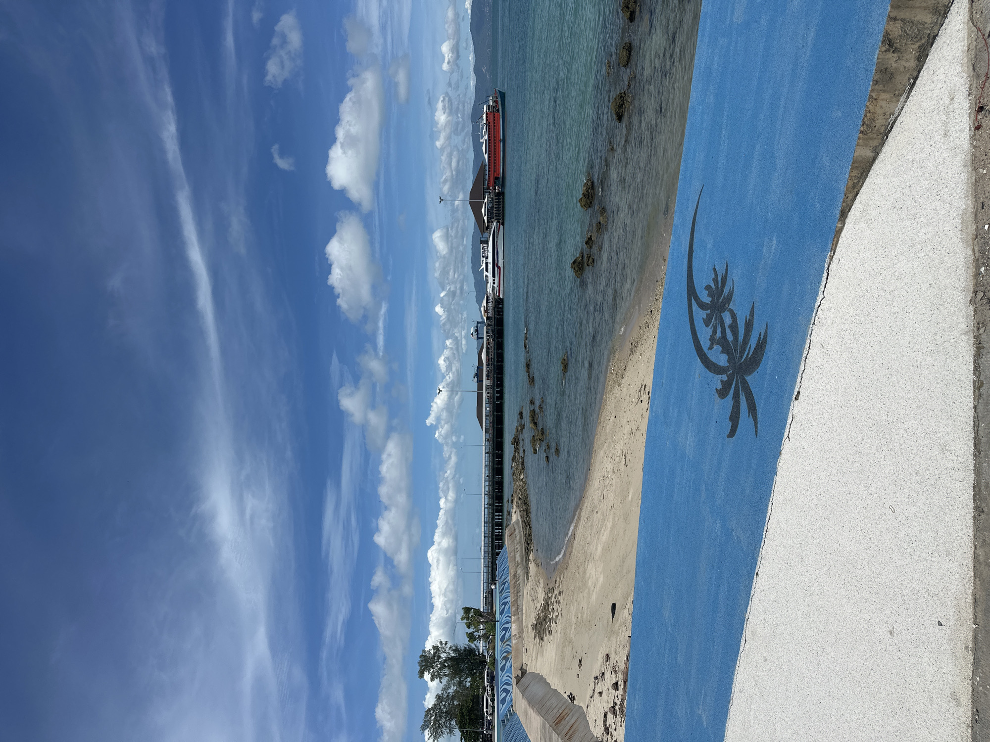 Naval ship docked at Koh Phangan pier, group activity nearby