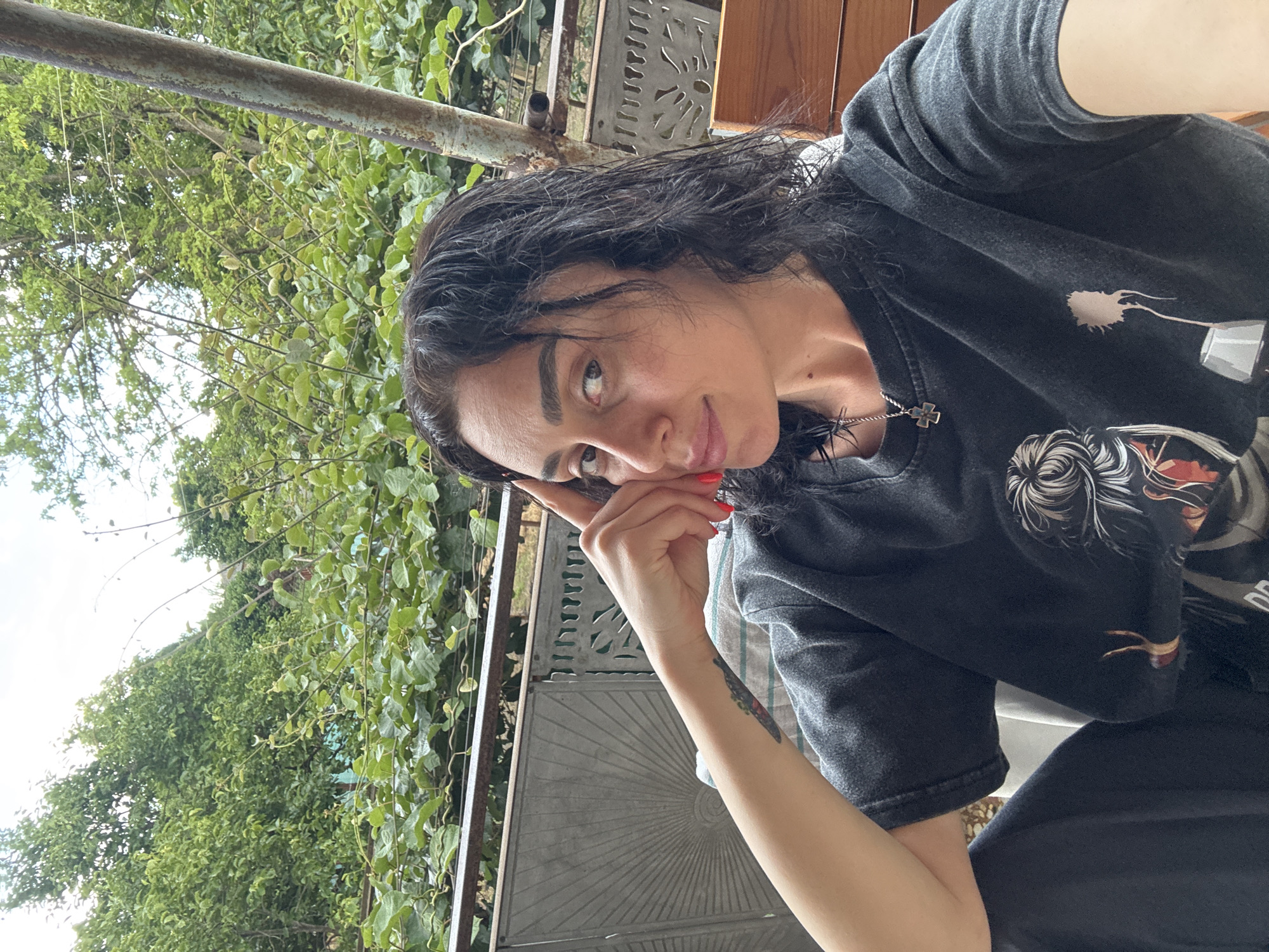 Woman takes selfies in garden setting in Kartubani, Georgia