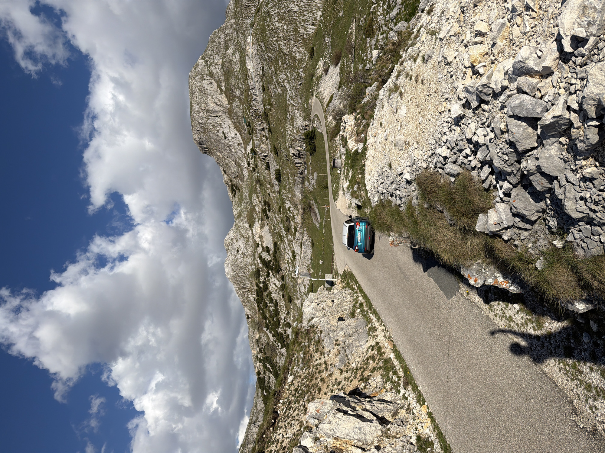 Turquoise car travels winding mountain road in Boričje, Montenegro