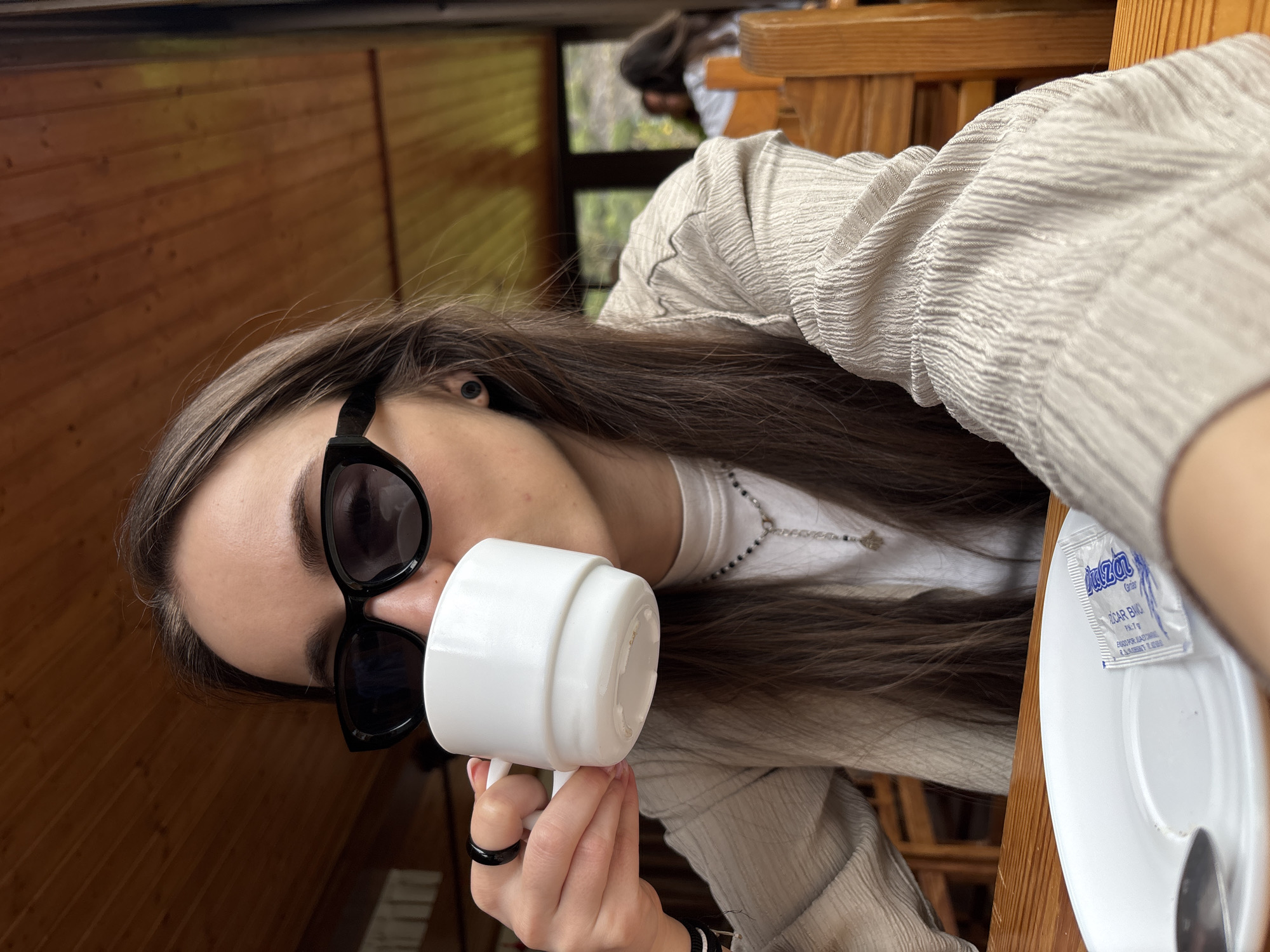 Woman enjoys morning coffee with mountain views in Spanish café