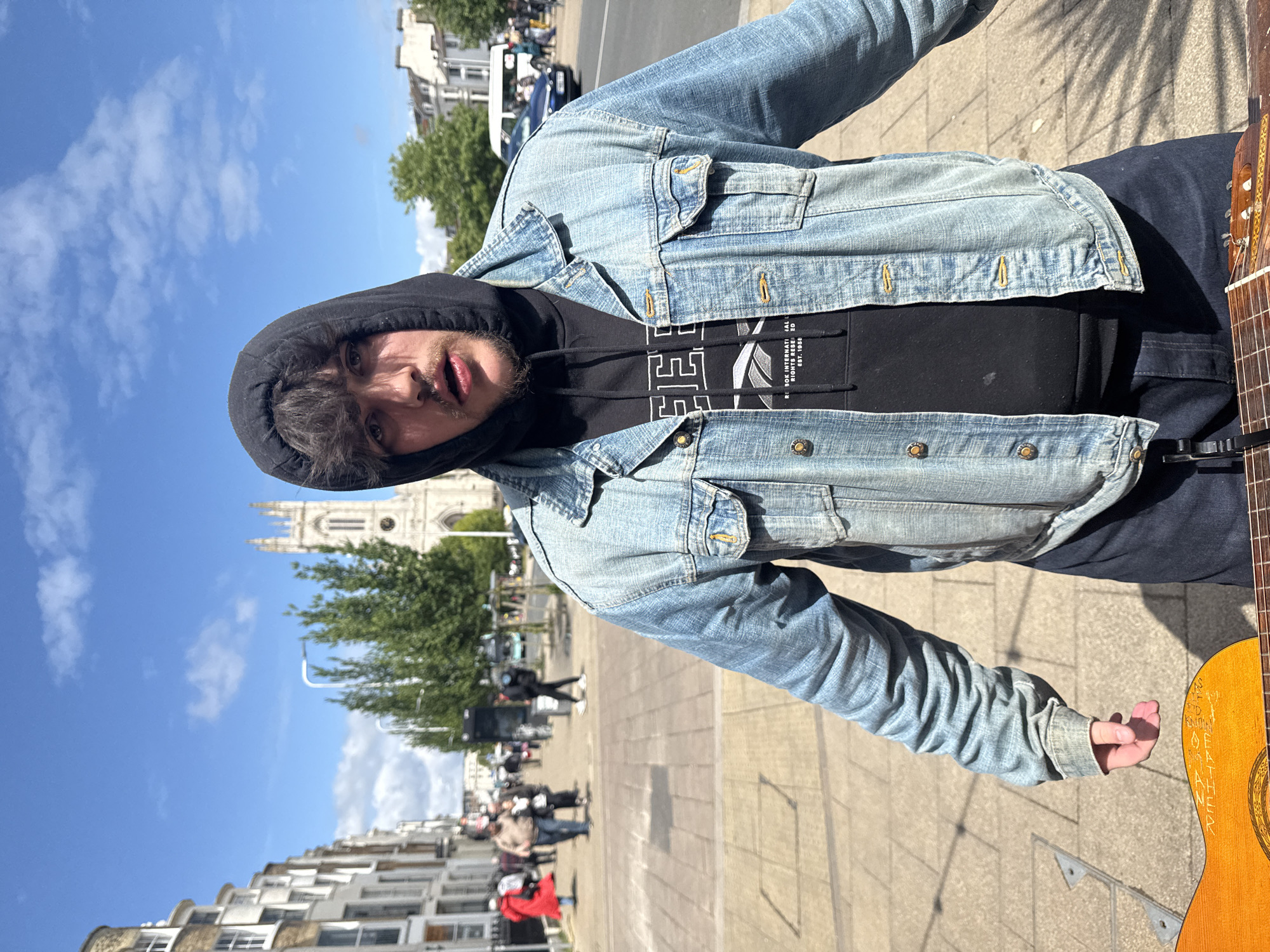 Man in denim jacket photographed on Brighton sidewalk