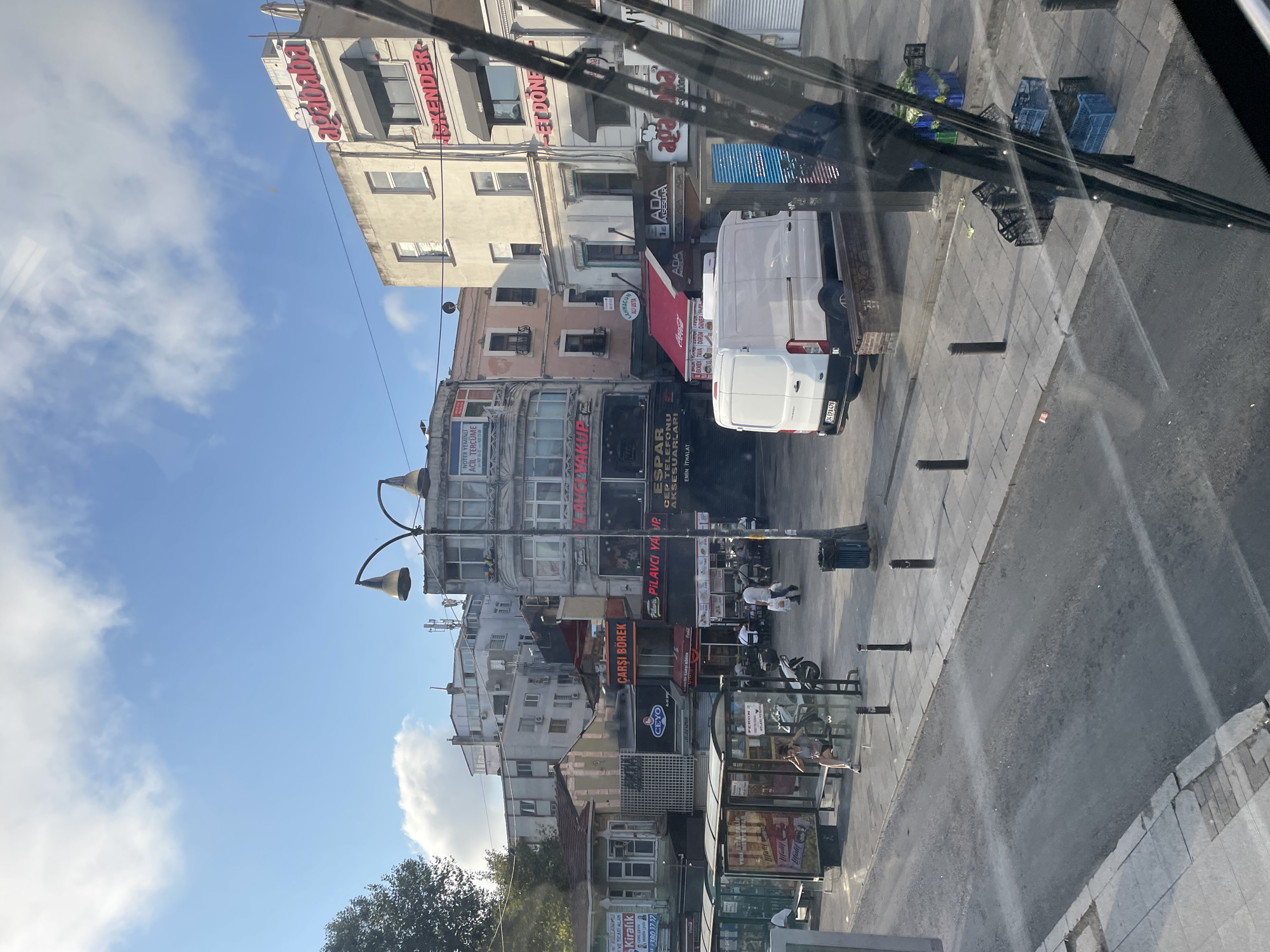 Kadıköy street scene: trams, buses, and shopfronts at dawn