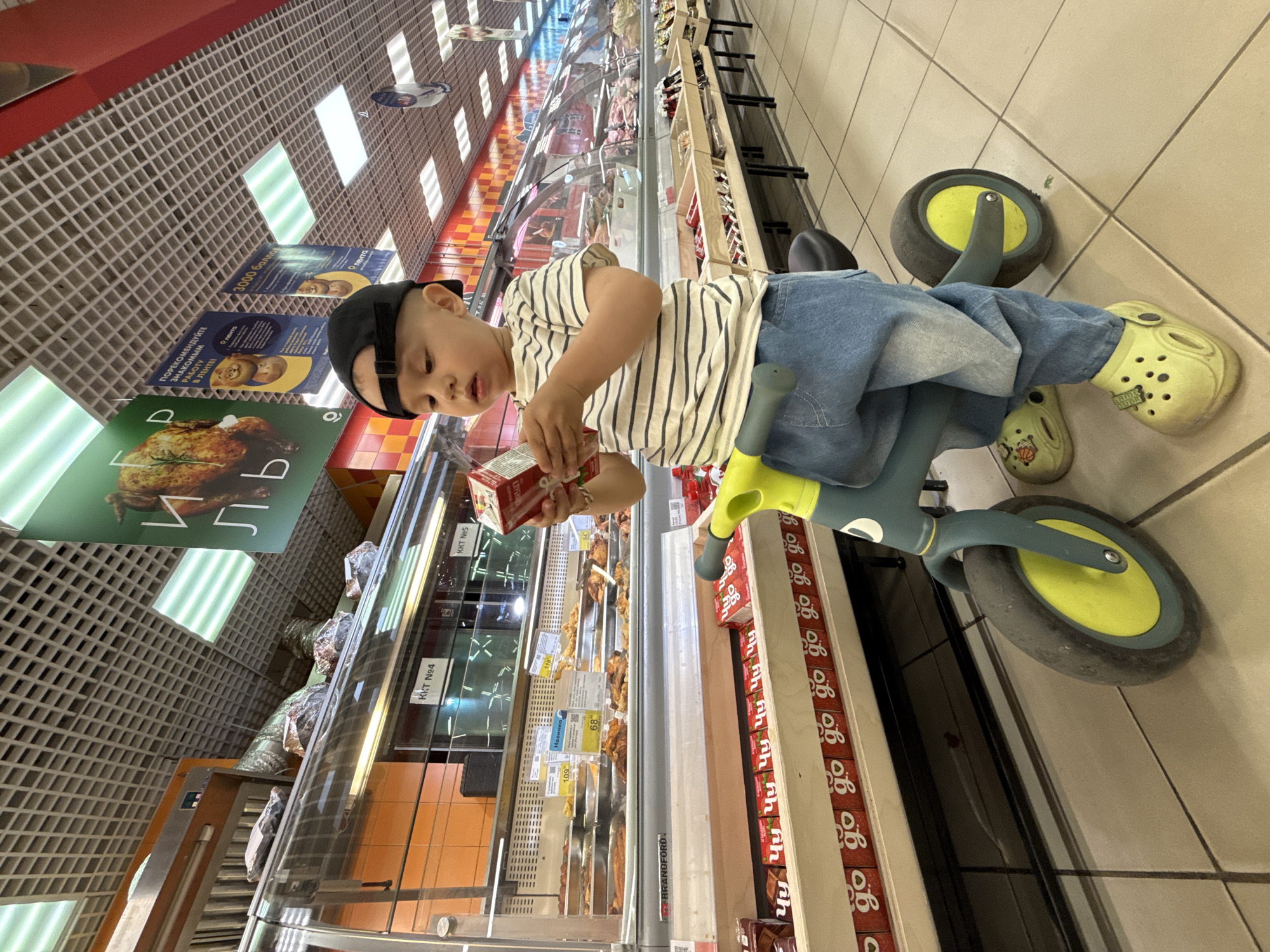 Family shopping trip with tricycle-riding child documented in Russia