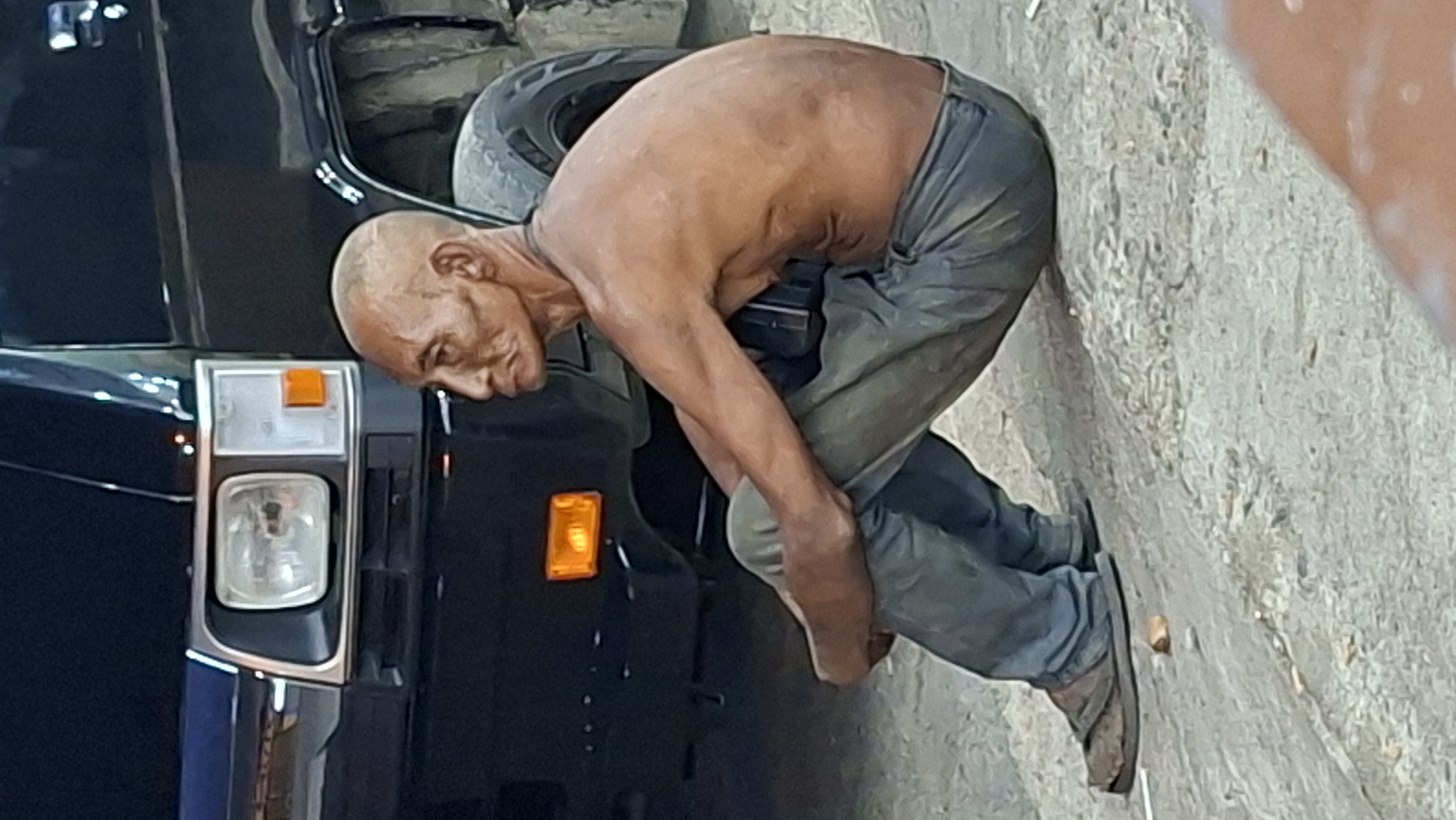 Street scenes in Lhokseumawe: a frail figure, food stall, and stranded ambulance