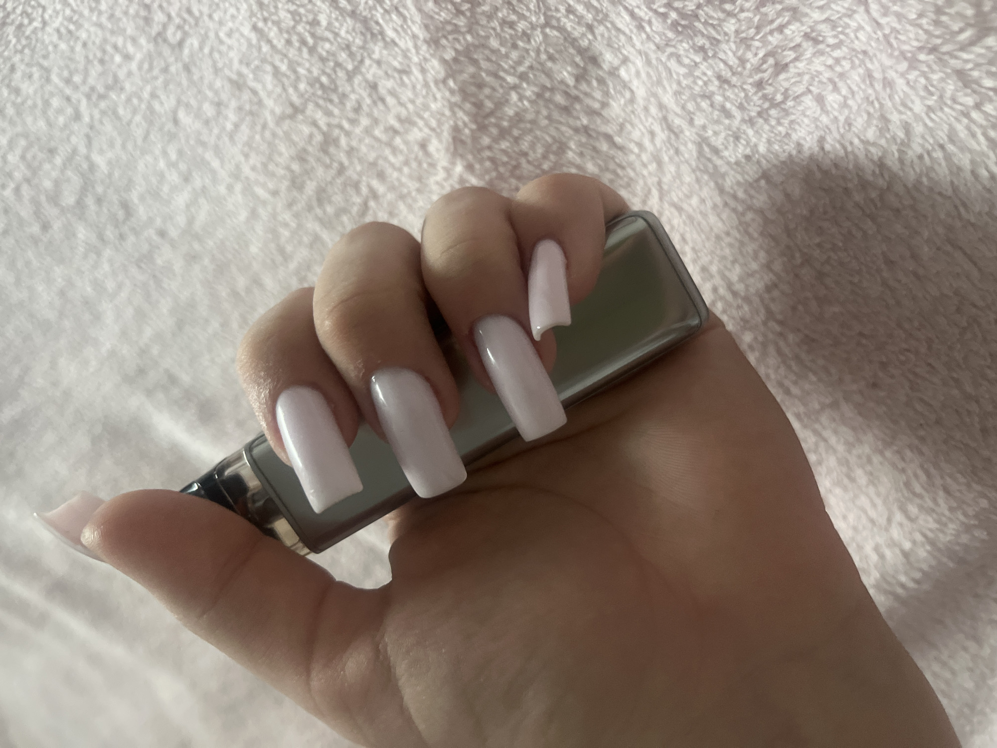 Person with decorated nails holds vape device in Russia