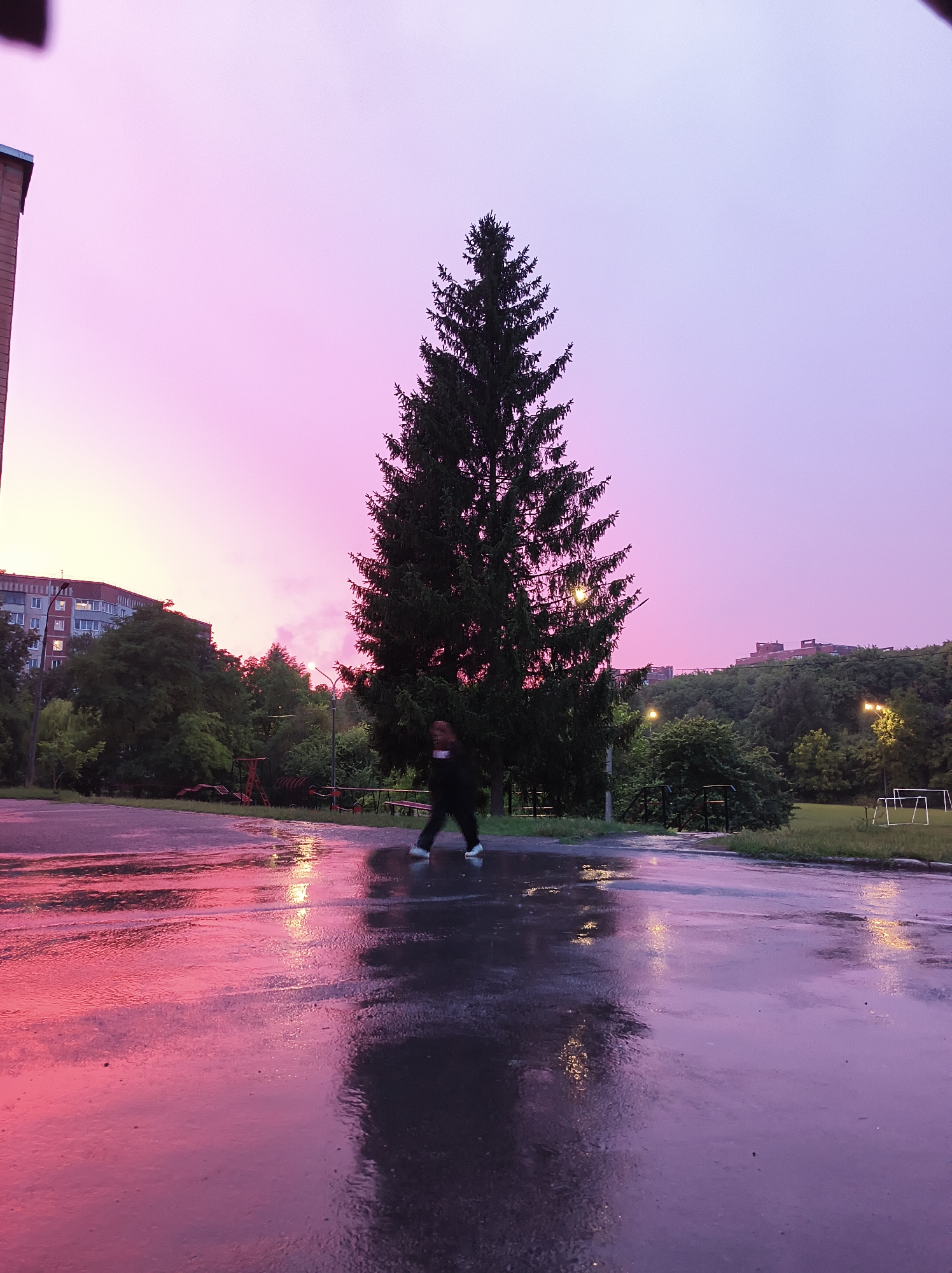 Rainy twilight across Ternopil streets and a local football field