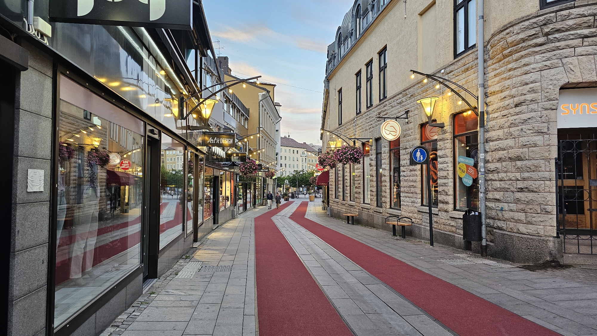 Linköping pedestrian street at dusk, red carpet and art installation