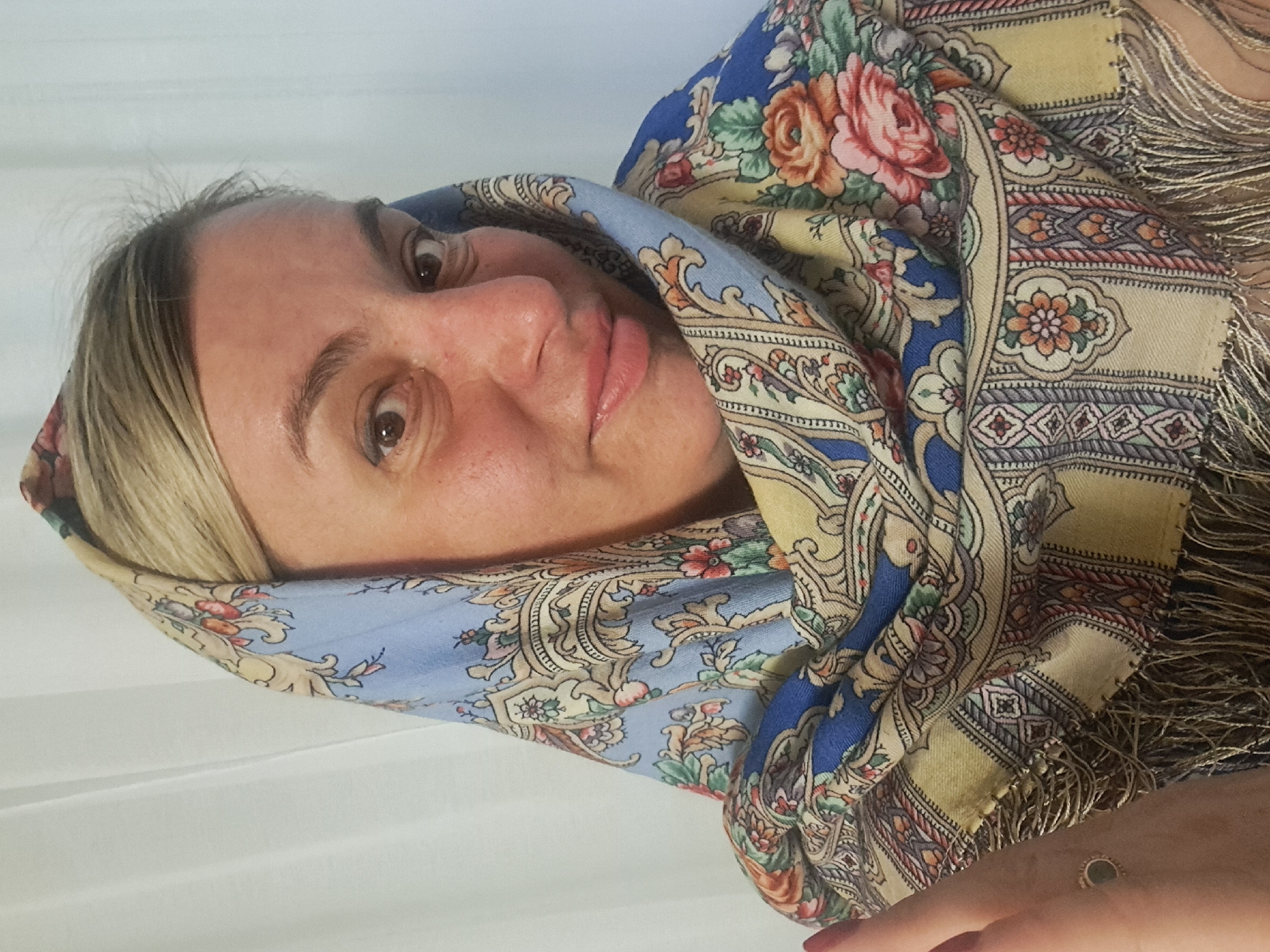 Woman displays floral scarves, cats rest in Elektrostal