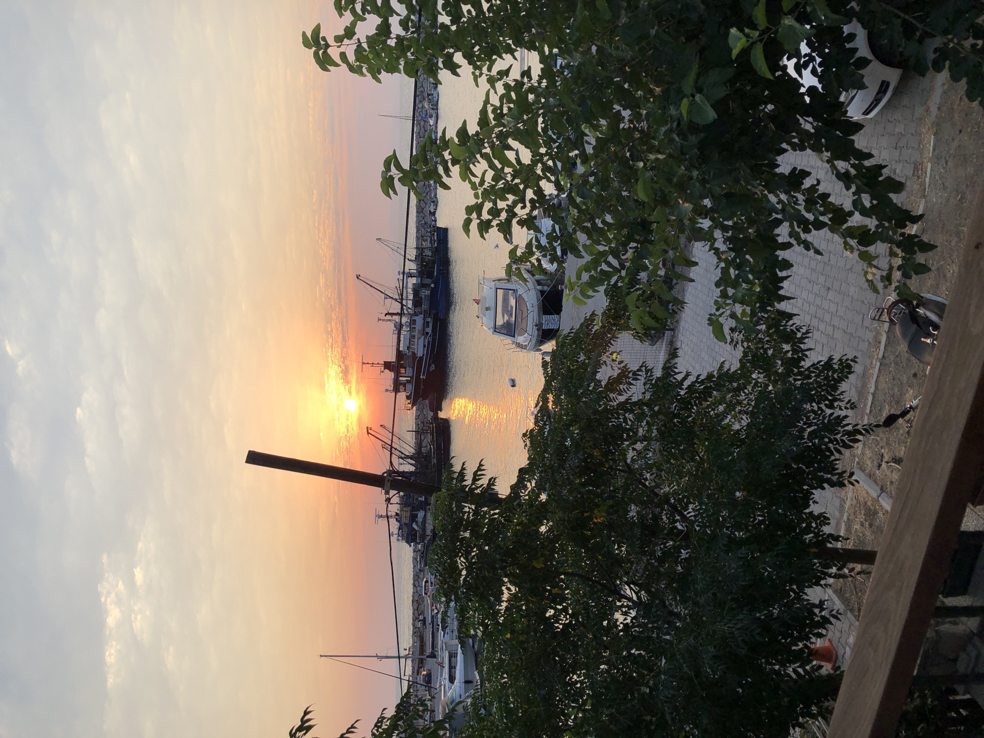 Sunset over Karaburun harbor, fishing boats at rest