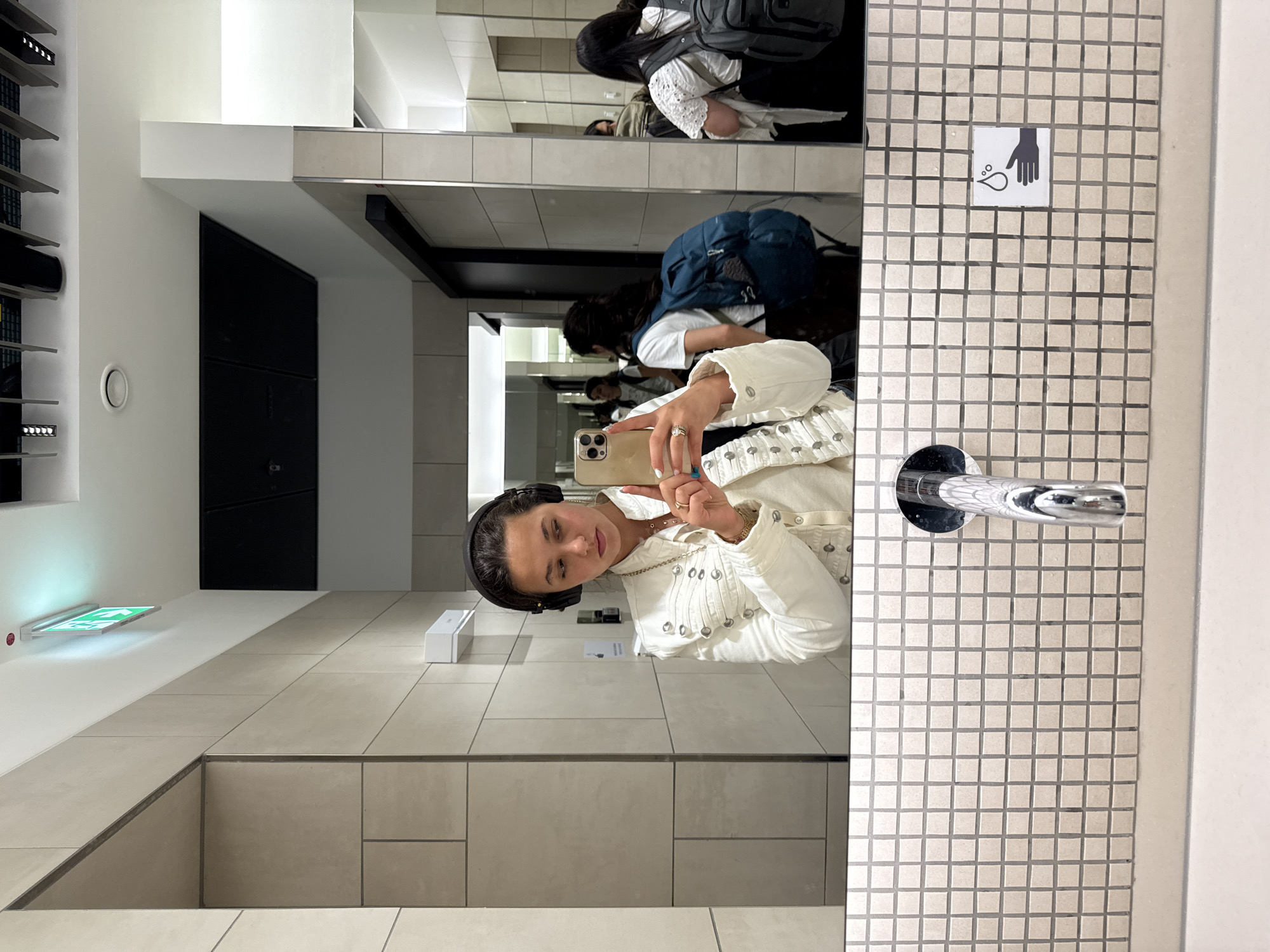 Mirror selfie in a Walldorf bathroom, headphones and white jacket