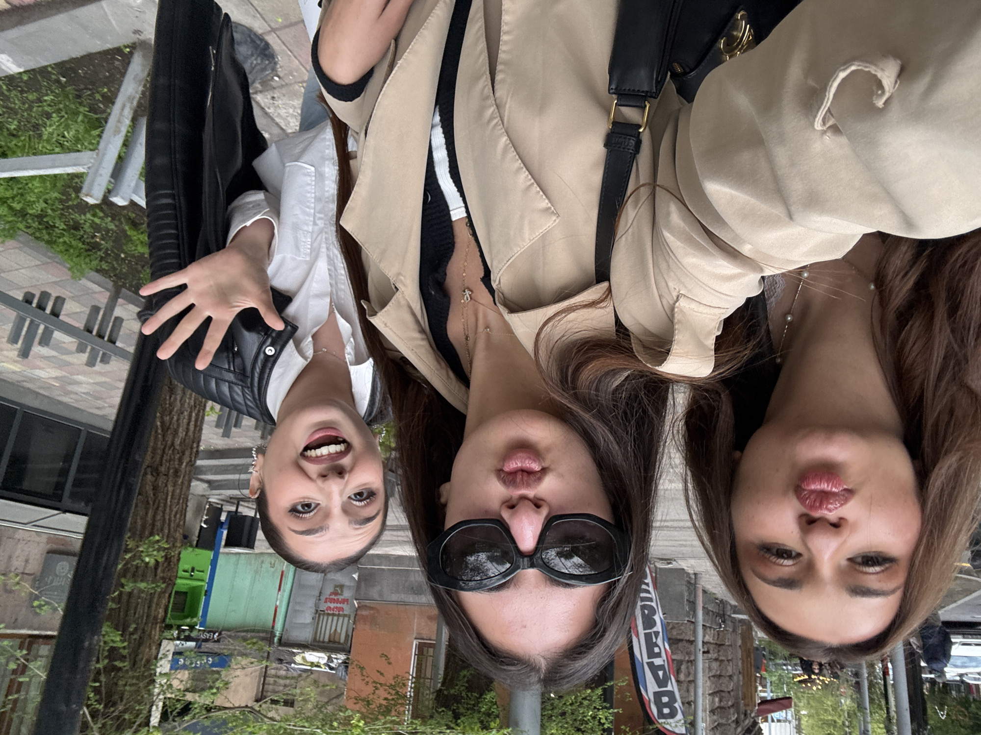 Three women take playful outdoor selfie