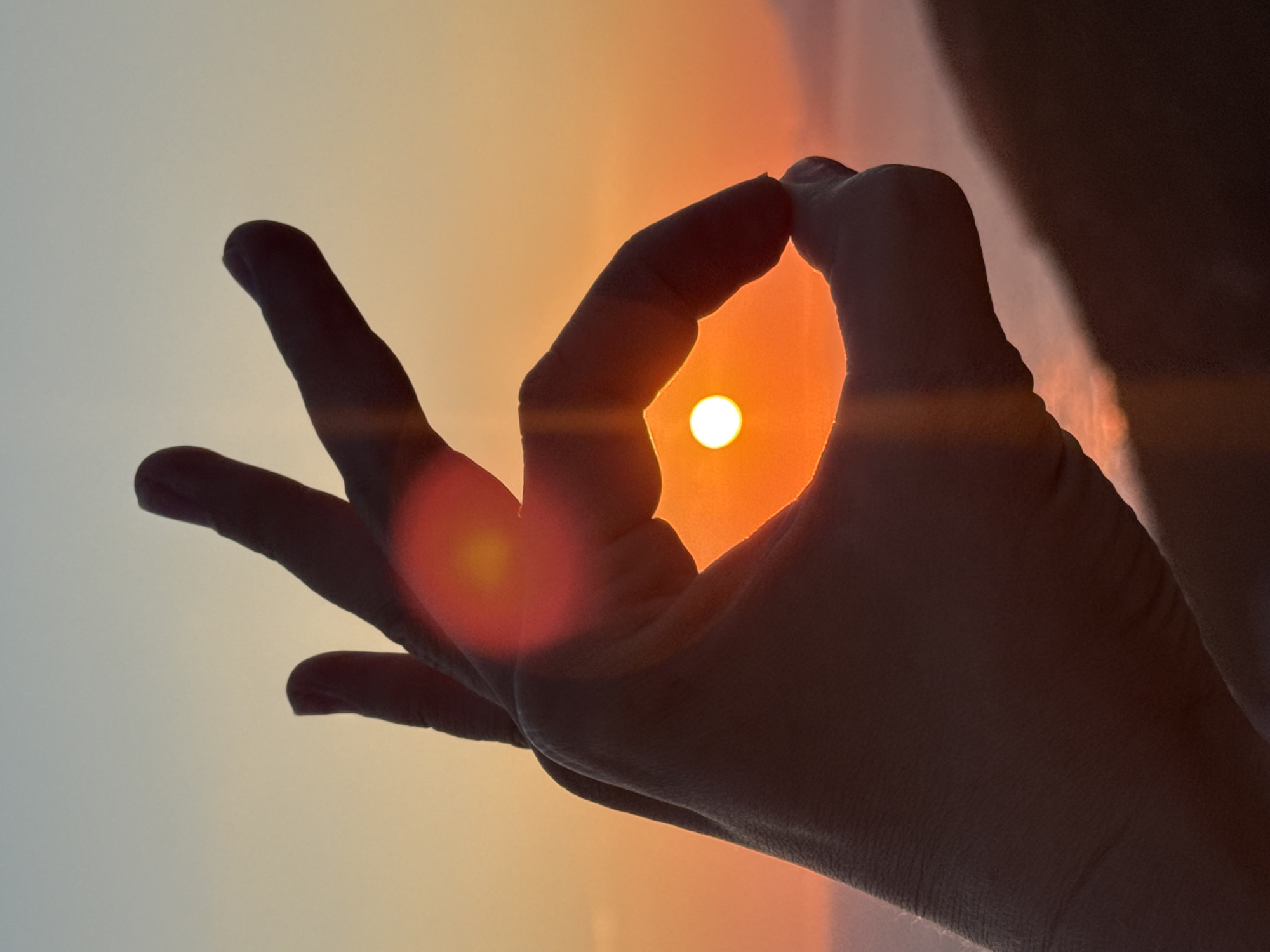 Sunset over the Adriatic, framed through hands and lenses