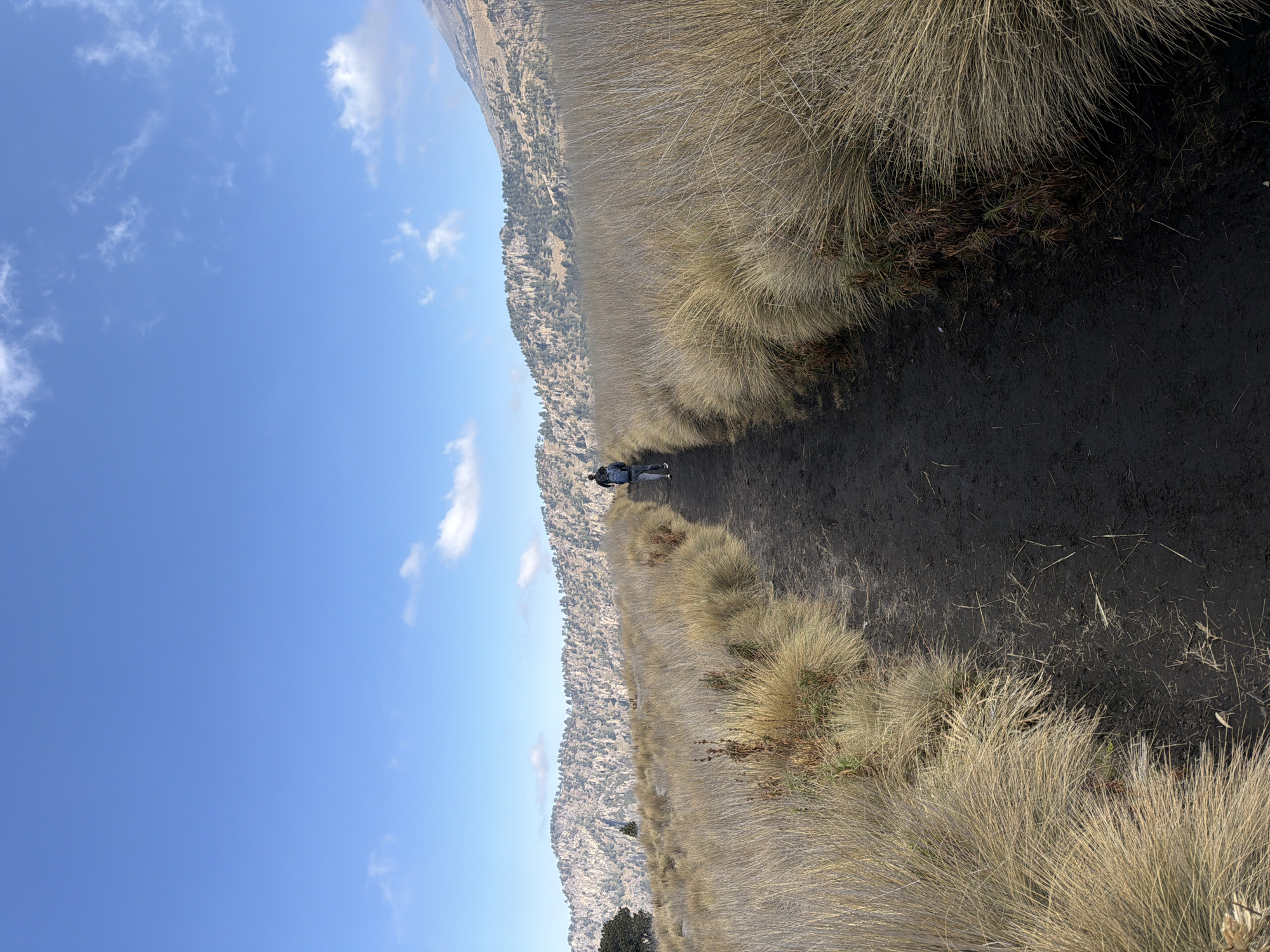 Walker traverses muddy trail toward snow-capped peak near Amecameca