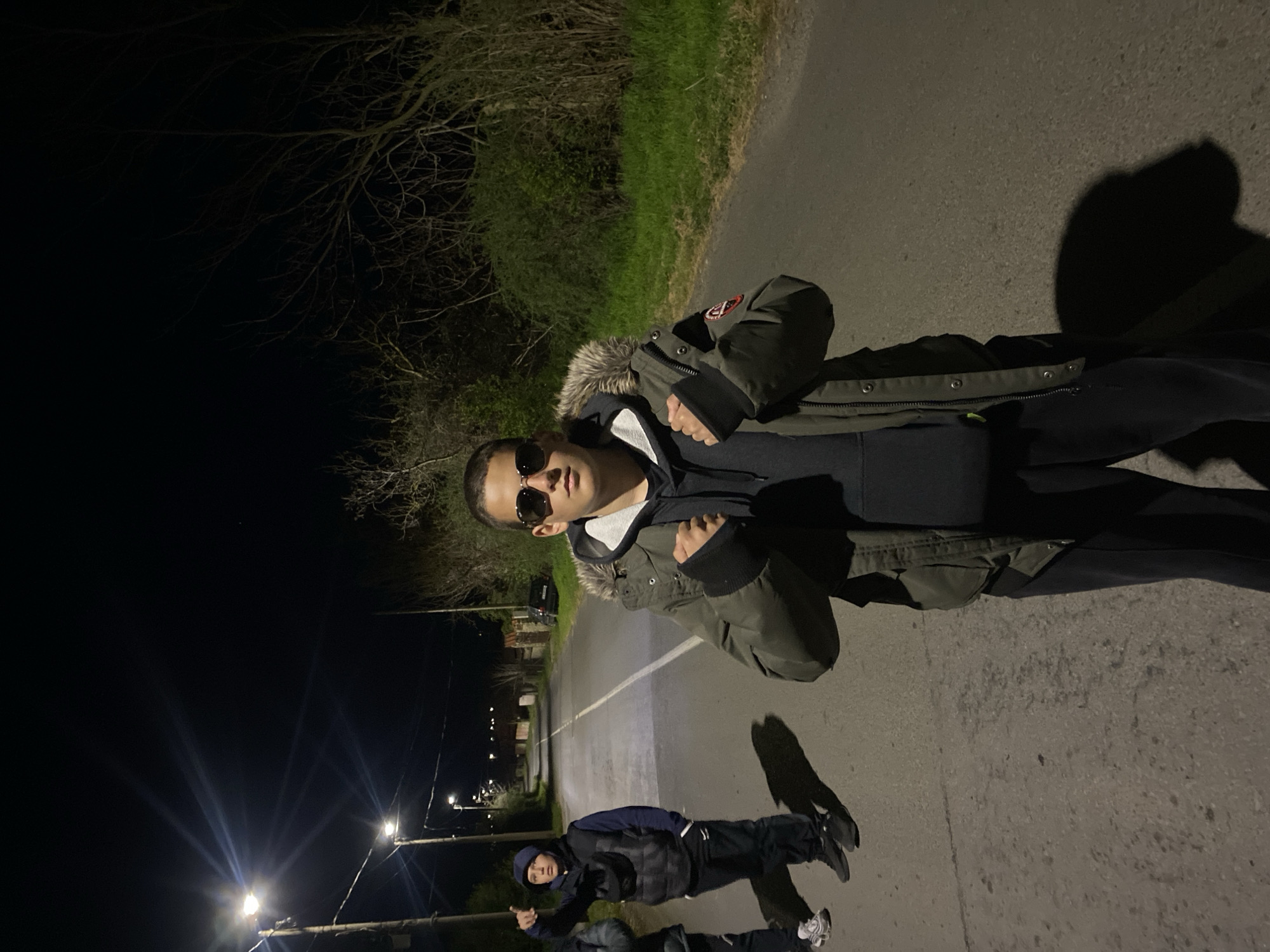 Teenagers gather on illuminated street in Goritsa, Bulgaria at night