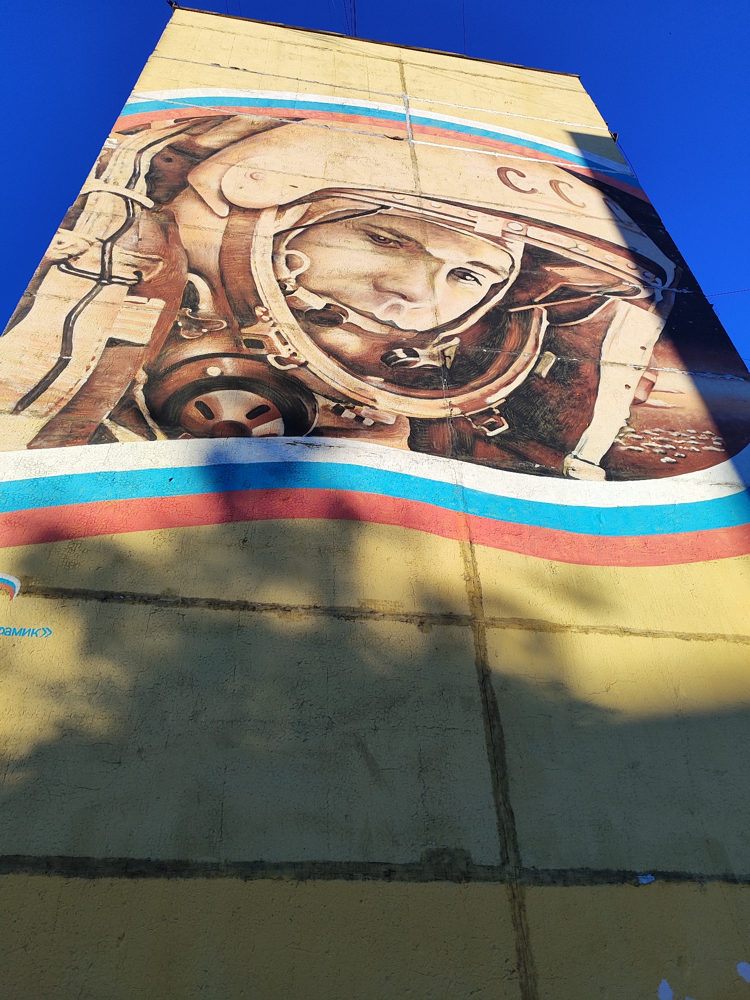 Quiet urban neighborhood: street art, parked cars, and a sleeping cat