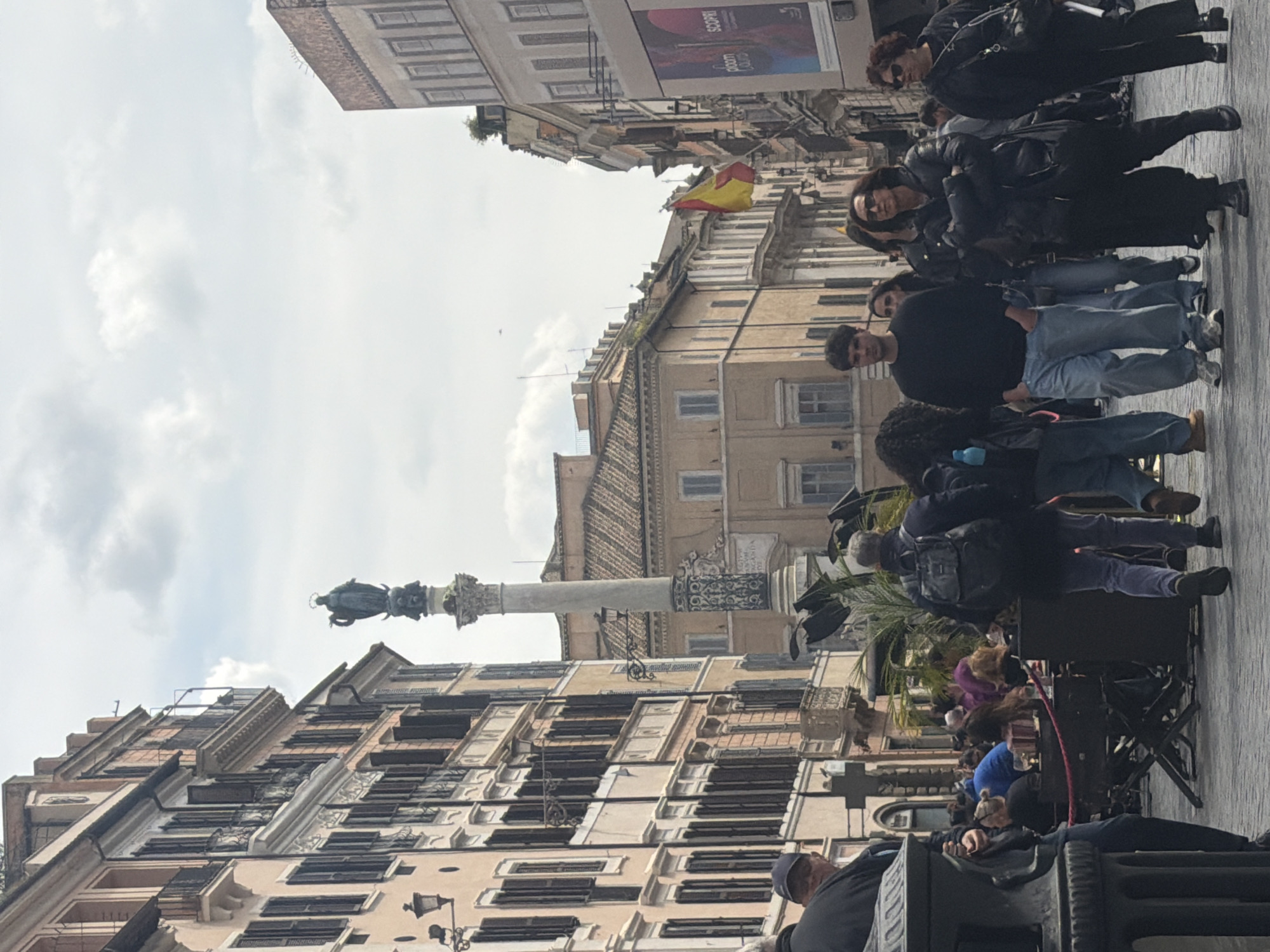 Historic Roman street scene captured with Spanish flag visible