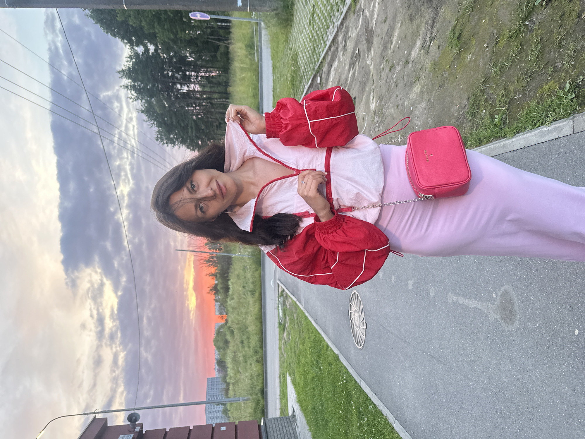 Sunset poses on a paved walkway, pink skies overhead