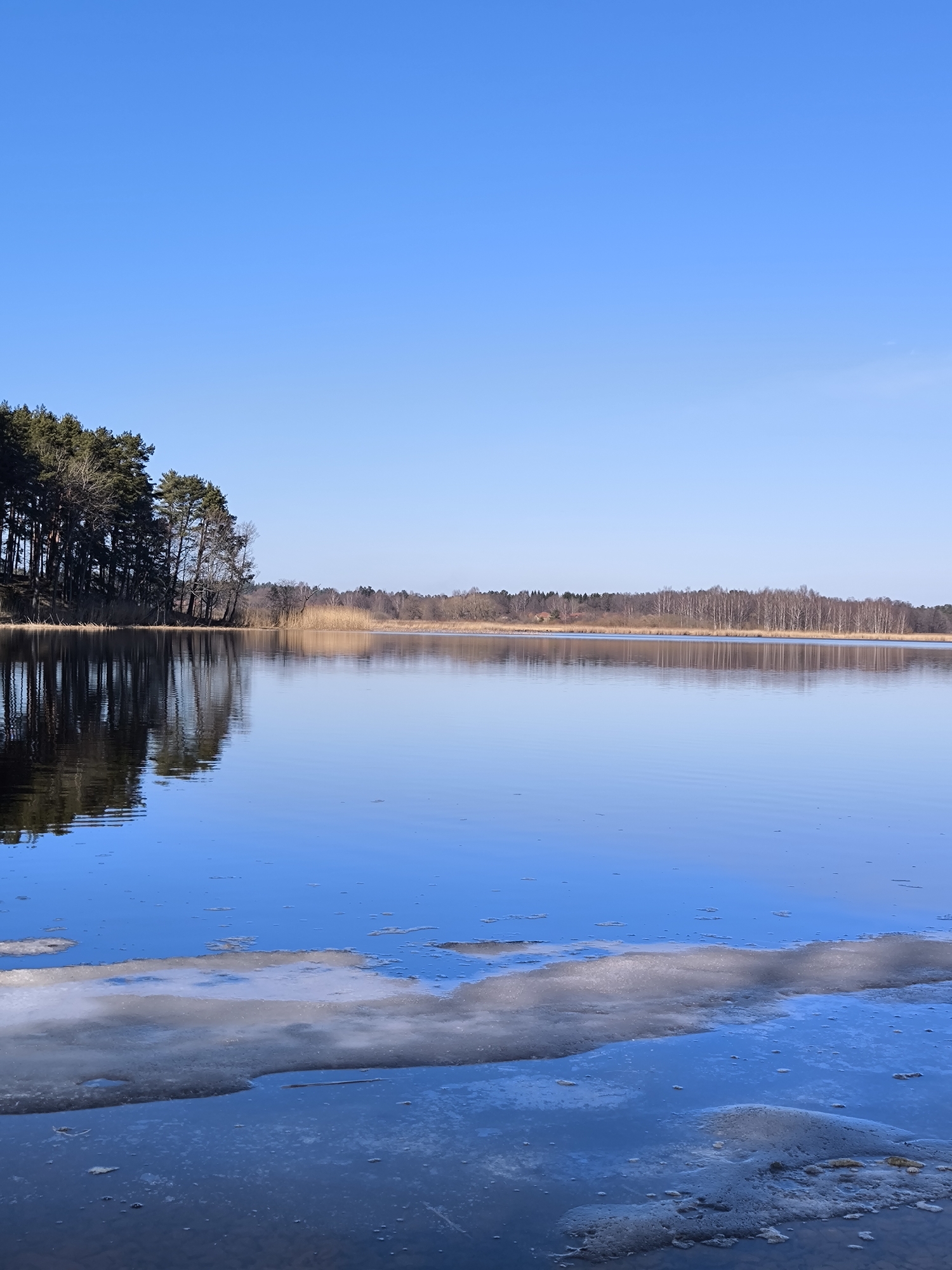 Clear skies over peaceful lake captured in Spuņciems, Latvia