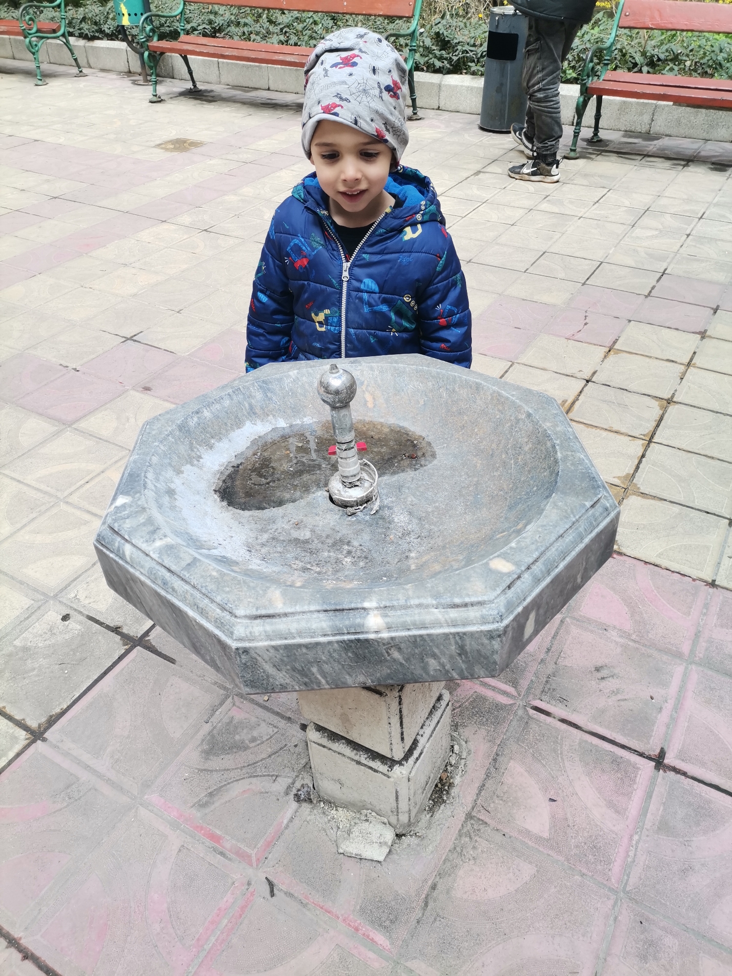Child at public drinking fountain in Dobrich Bulgaria