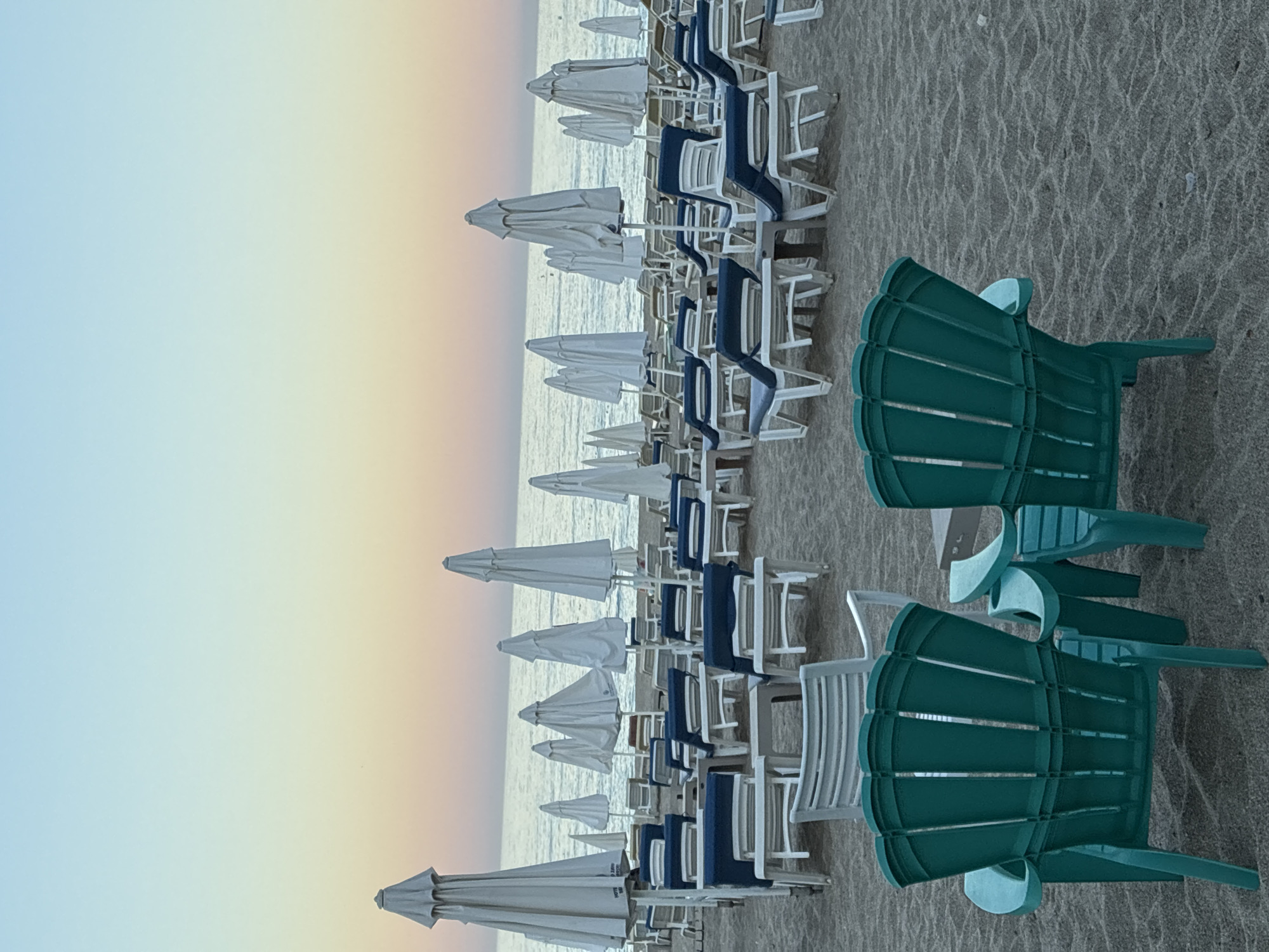 Alanya beach at golden hour, chairs, palms, and calm water