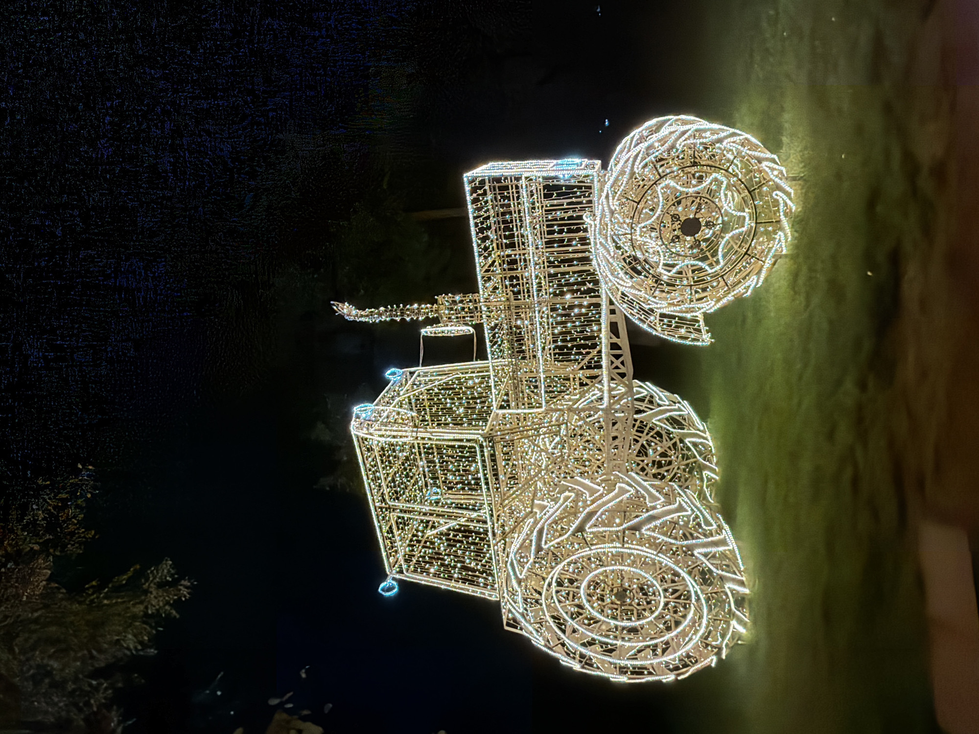 Illuminated tractor sculpture display documented in Minsk residential area