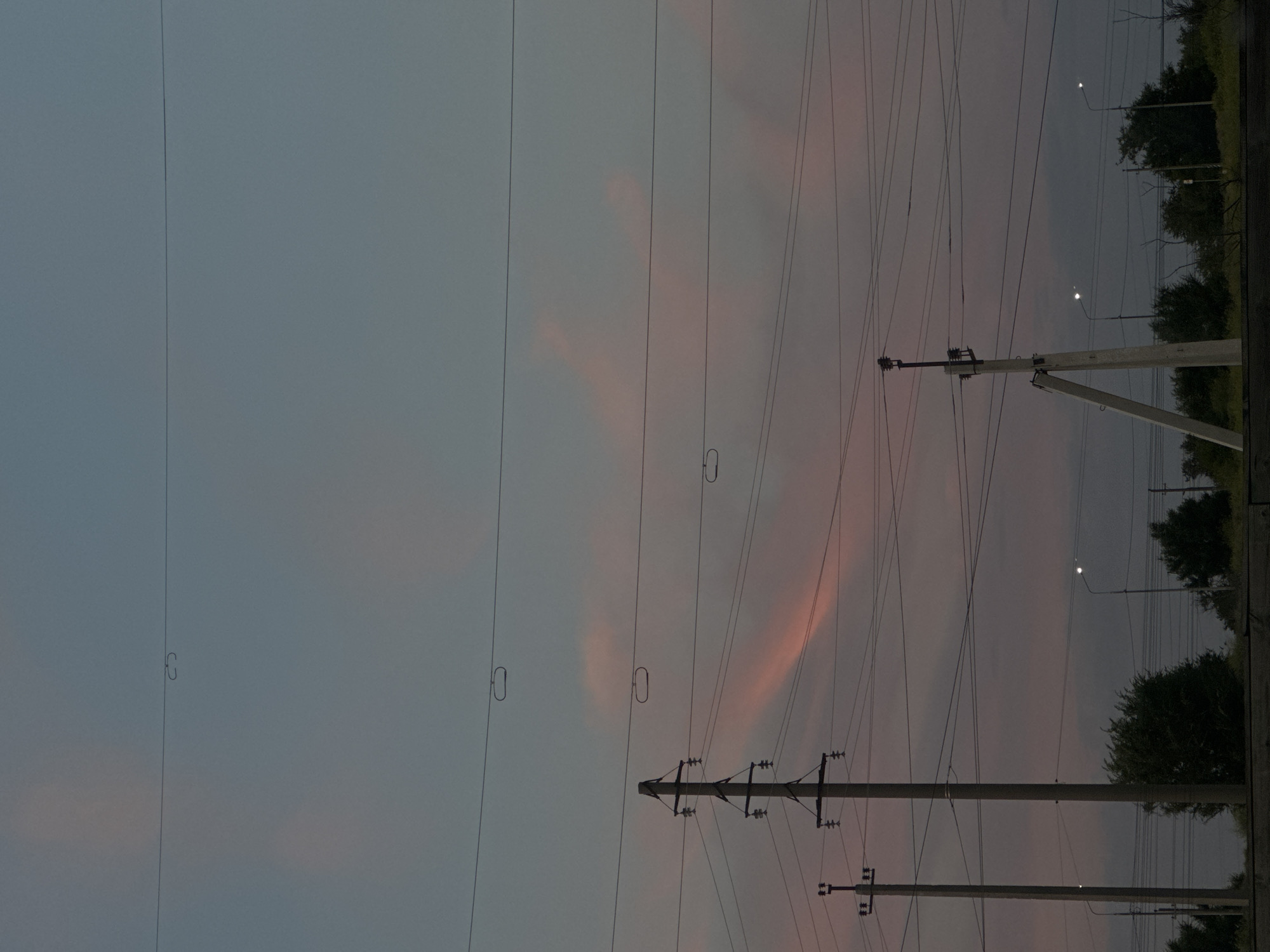 Power lines and utility poles against a fading twilight sky