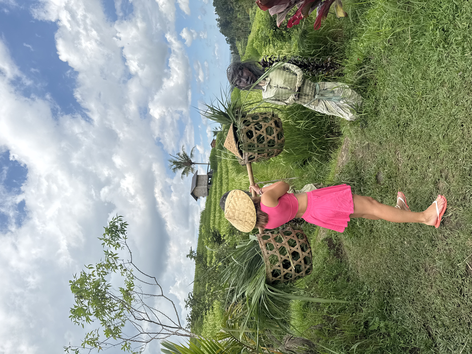 Woman tends rice paddies amid scarecrows in Penebel, Indonesia
